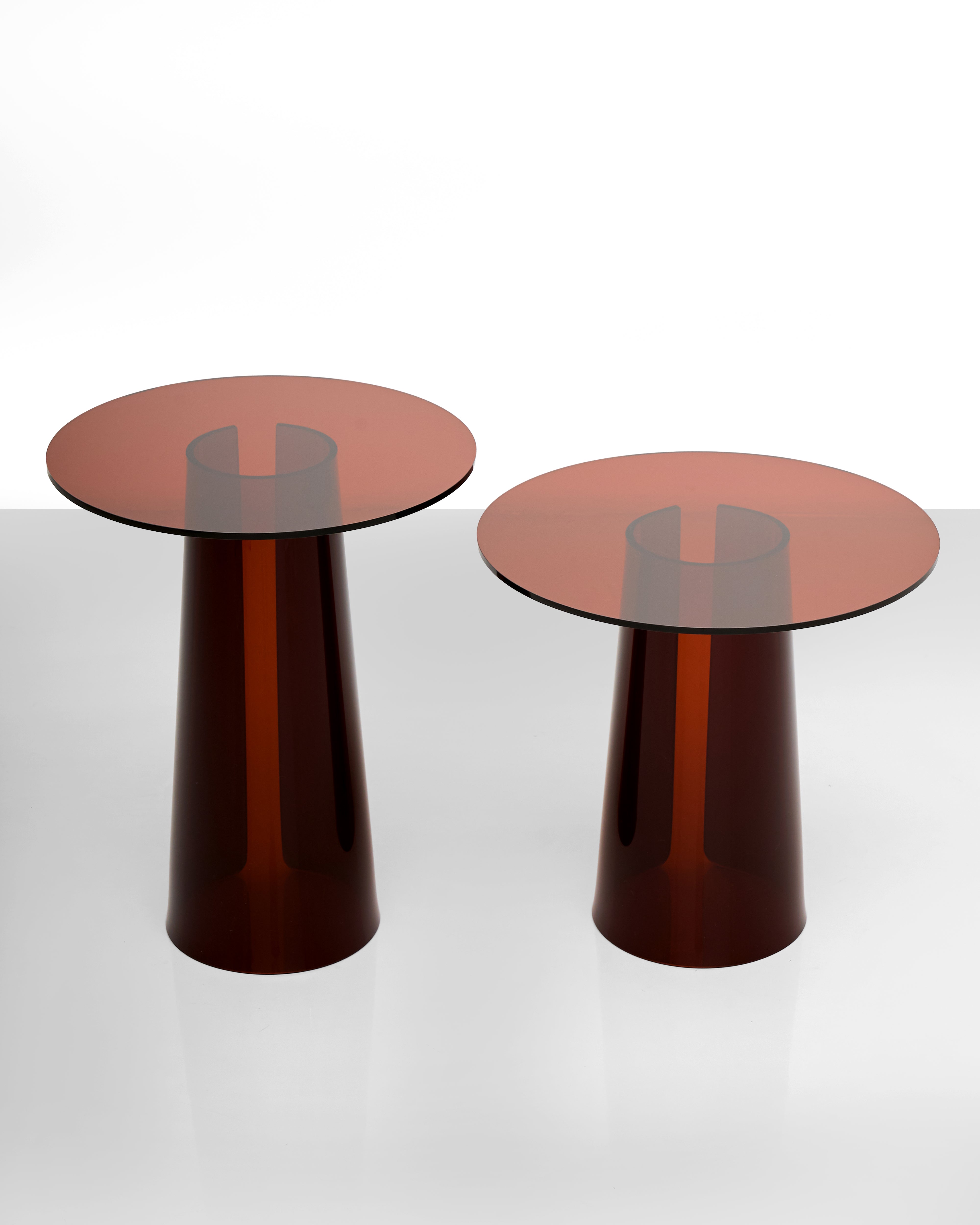 Two brown cylindrical side tables acrylic with reflective tops on a white background