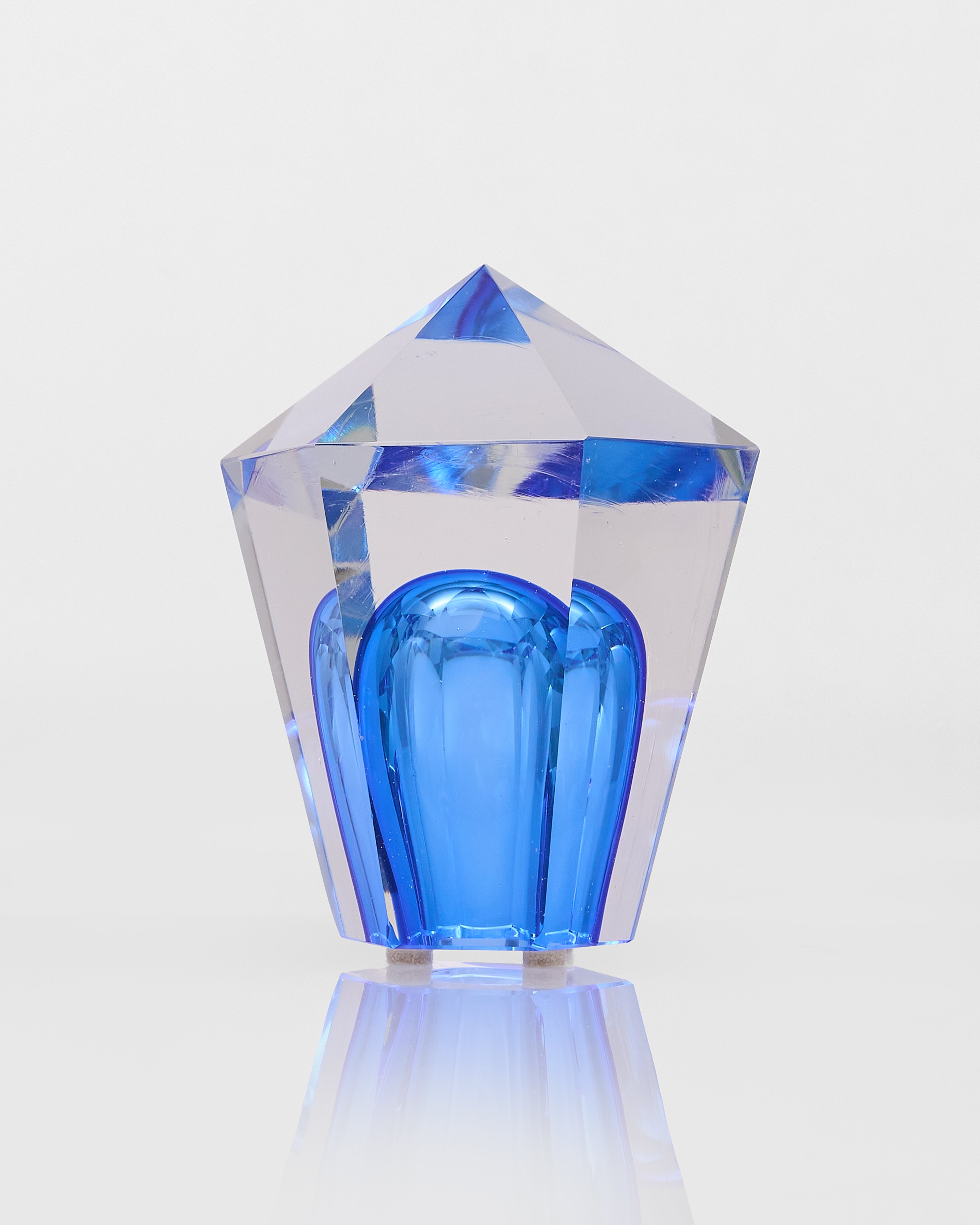 Crystal-like object with blue interior on a light gray background