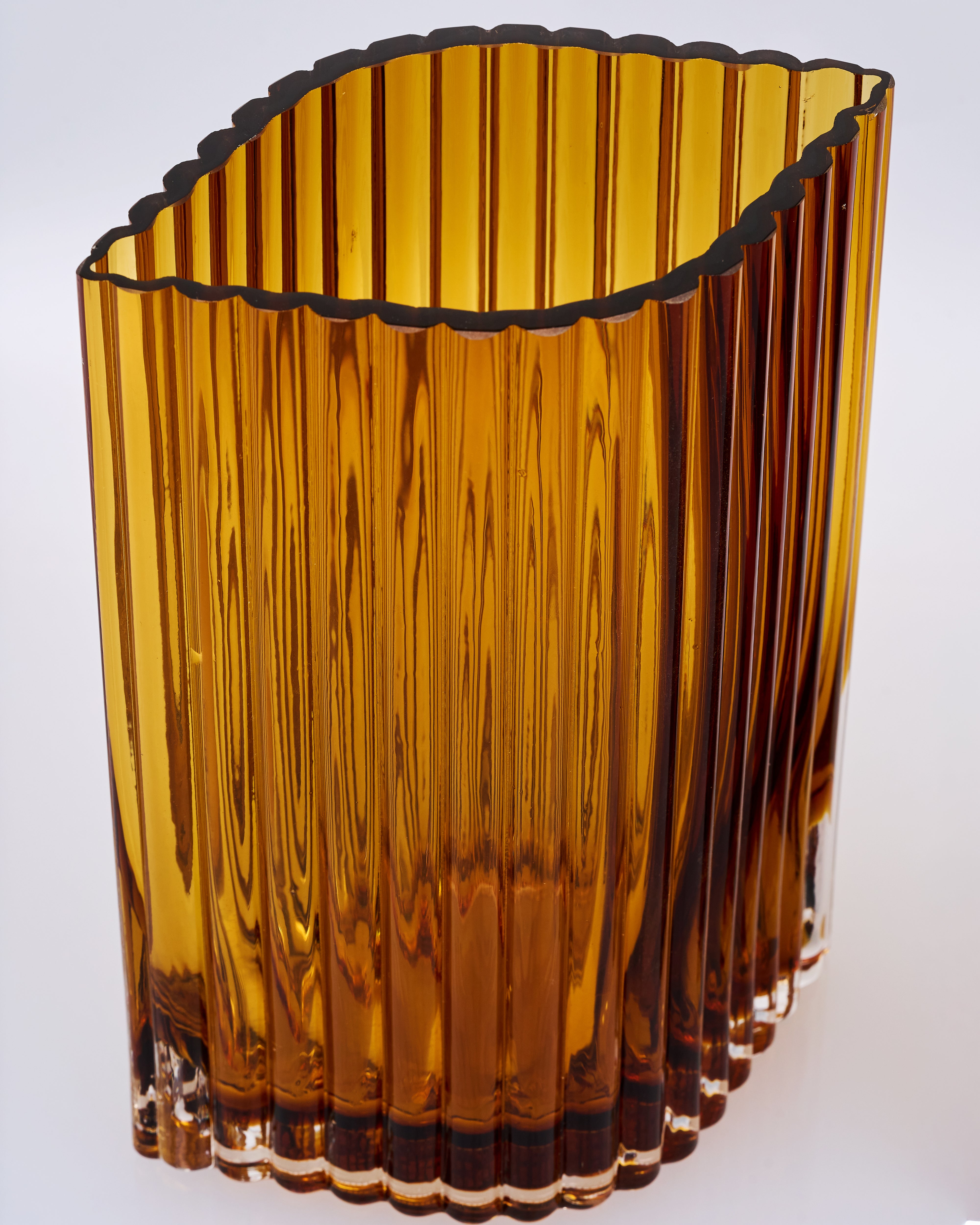 Brown glass vase with wavy design on a white background