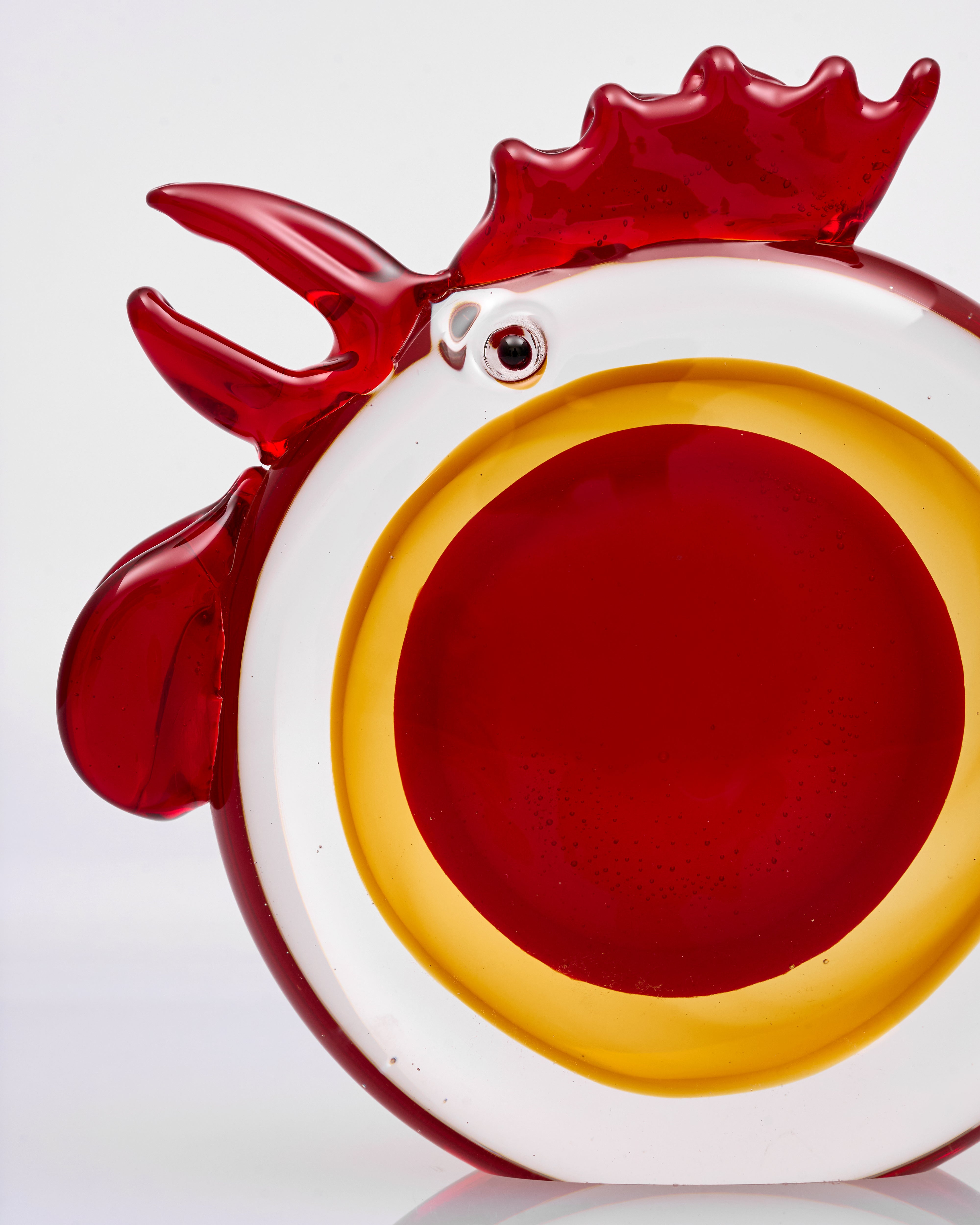 Glass object shaped like a rooster on a white background