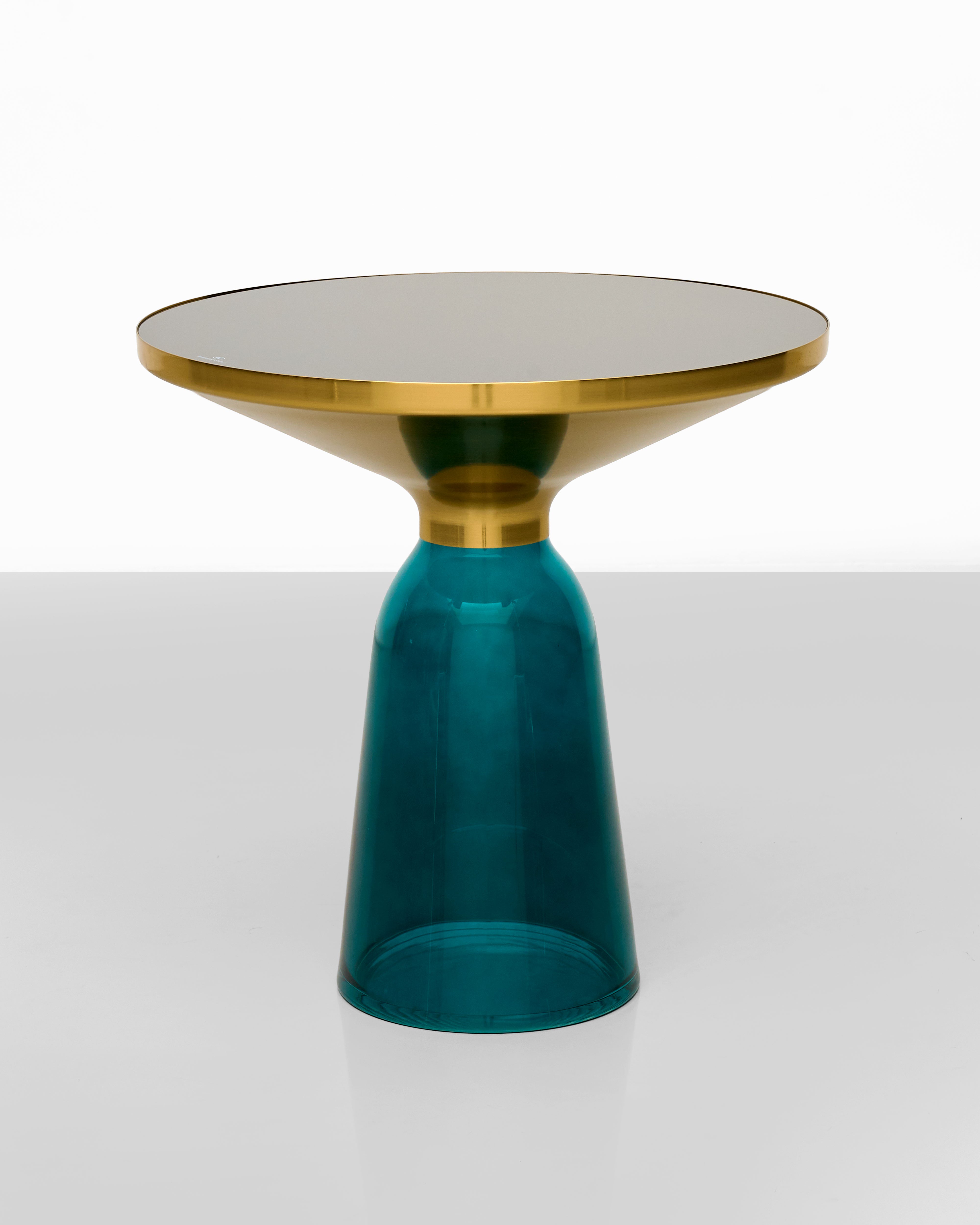 Side glass table with gold top and teal base on a white background