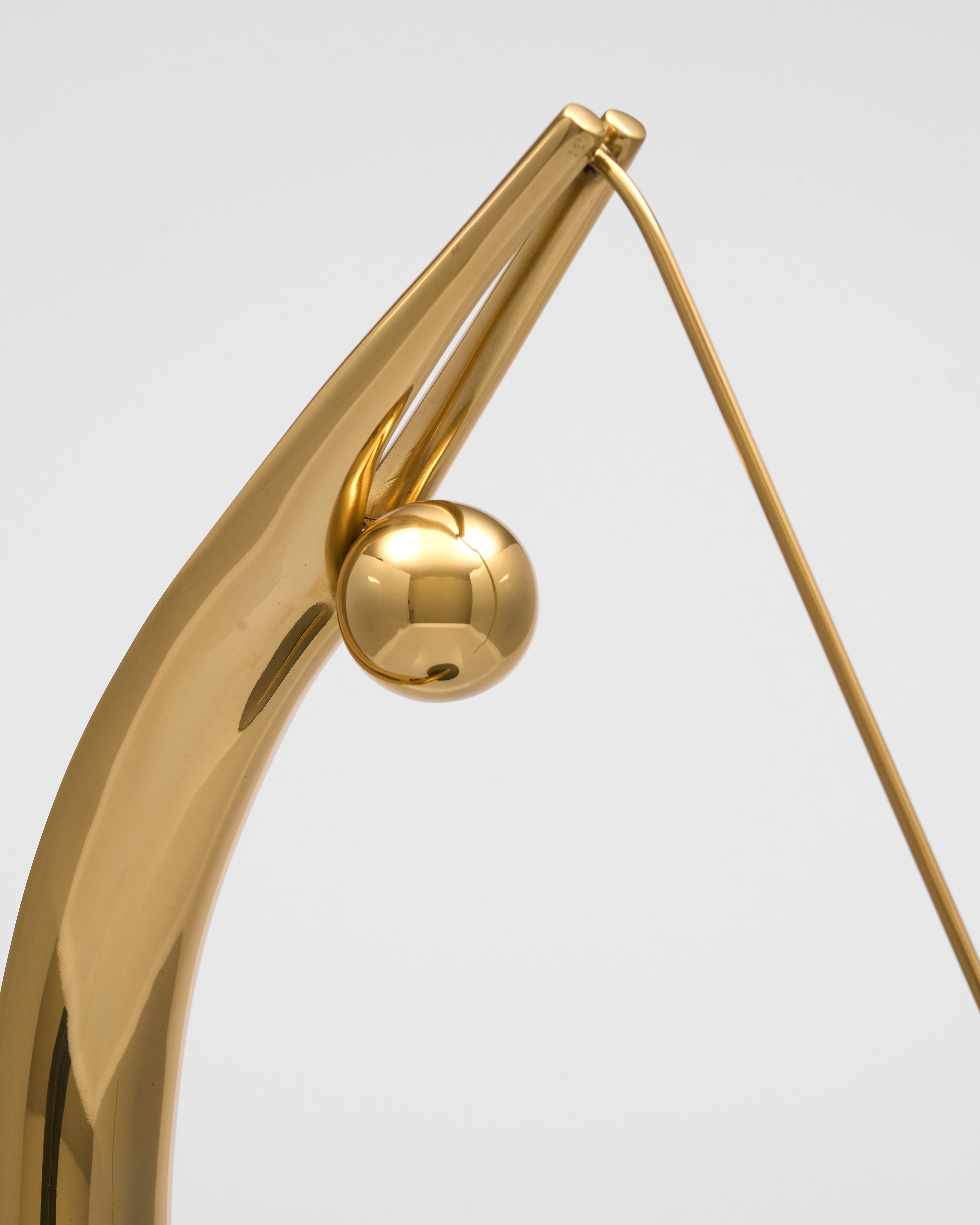 Gold earring with a spherical design on a light gray background