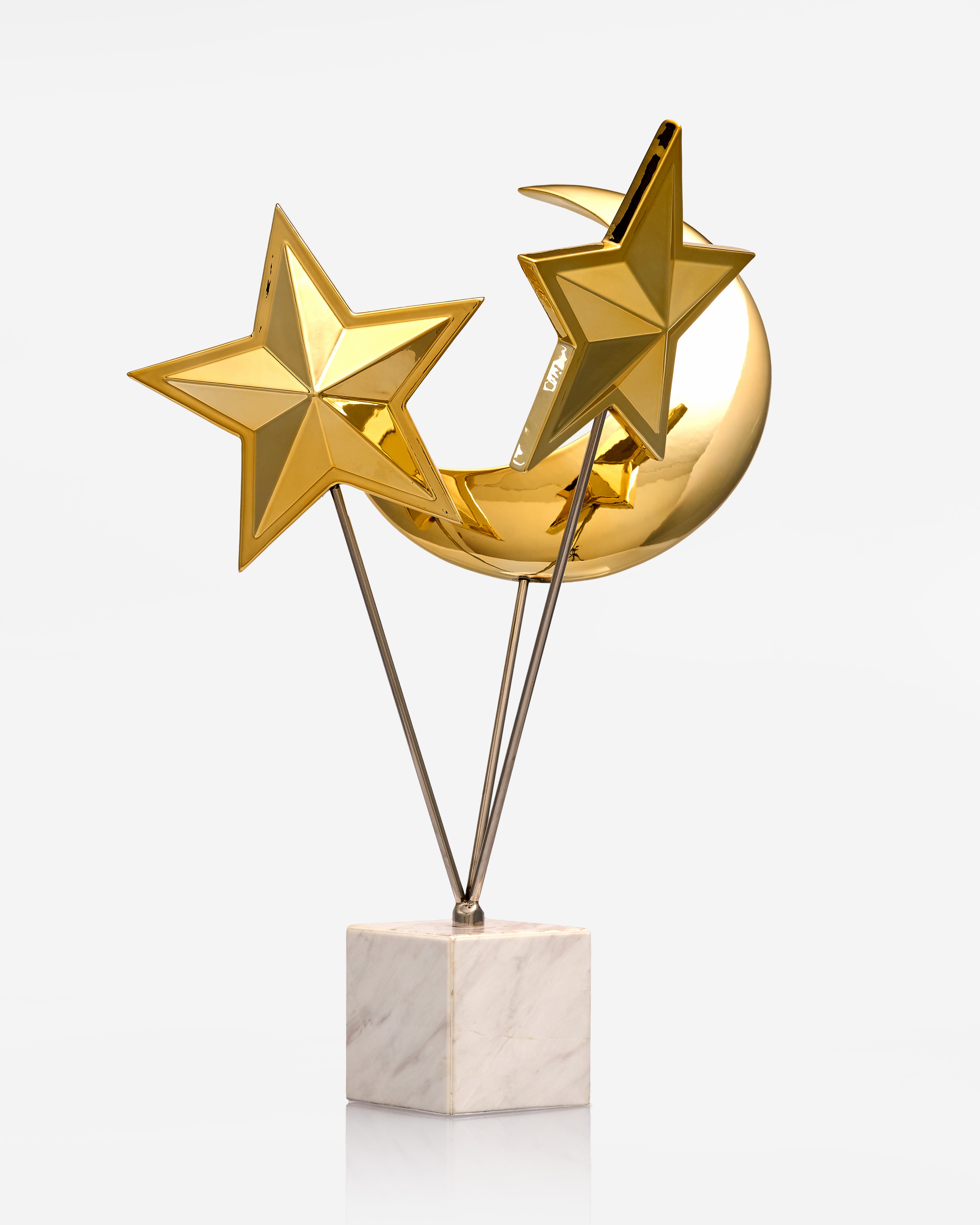 Gold star and moon trophy decor on a marble base against a white background