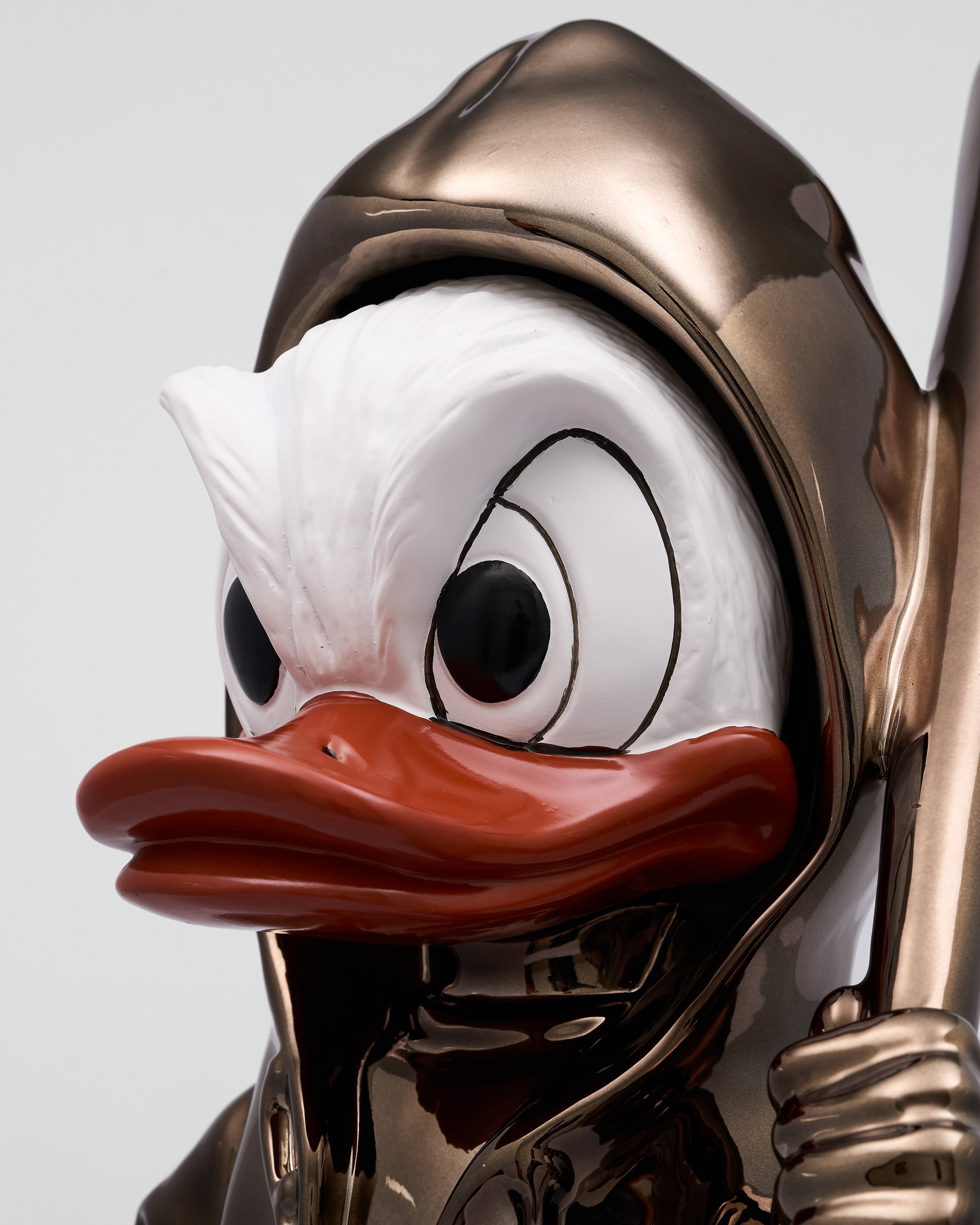 Metallic Donald Duck figurine with a spear on a gray background