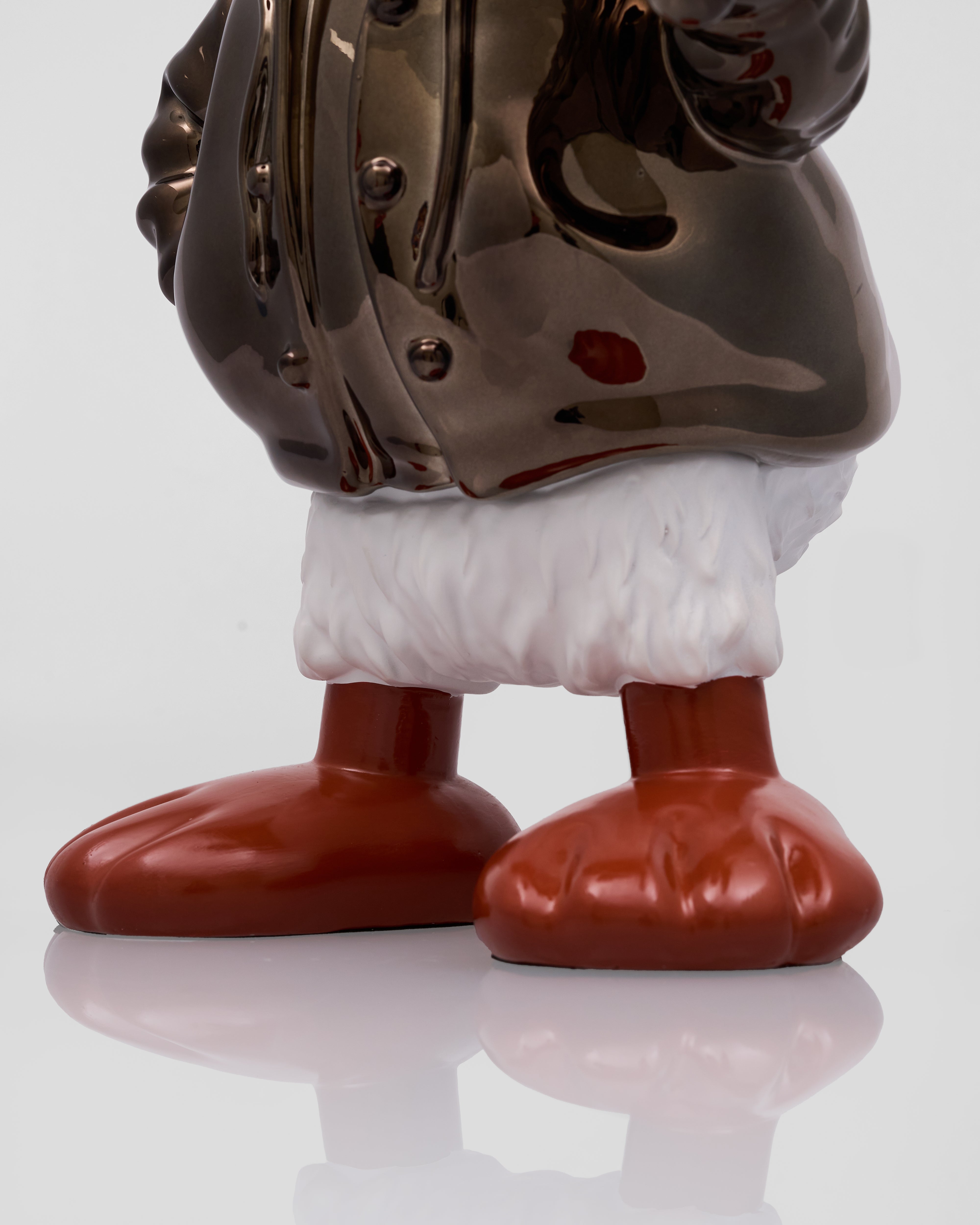 Close-up of a metallic figure with a reflective surface on a white background