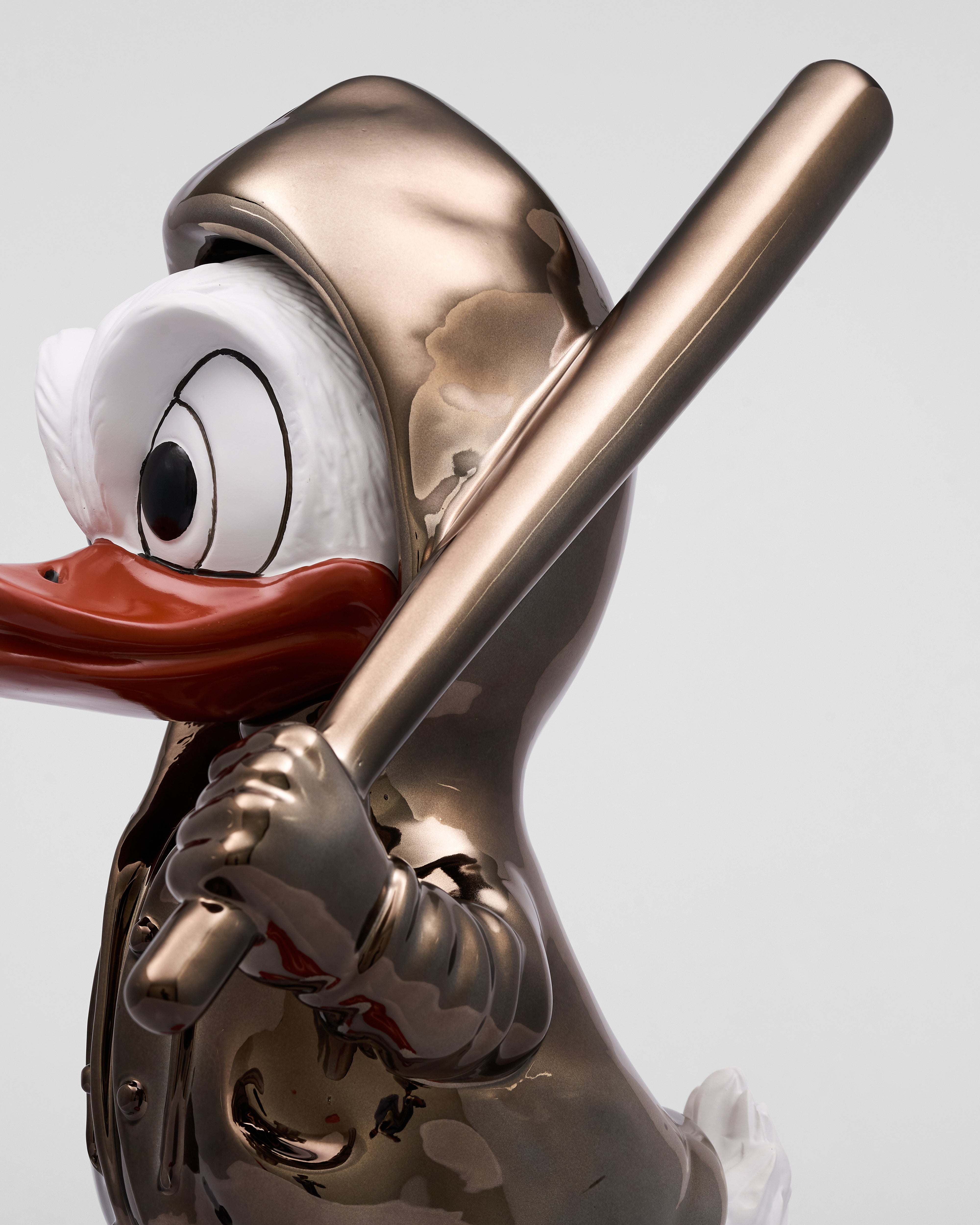 Metallic sculpture of a cartoon character holding a baseball bat on a white background