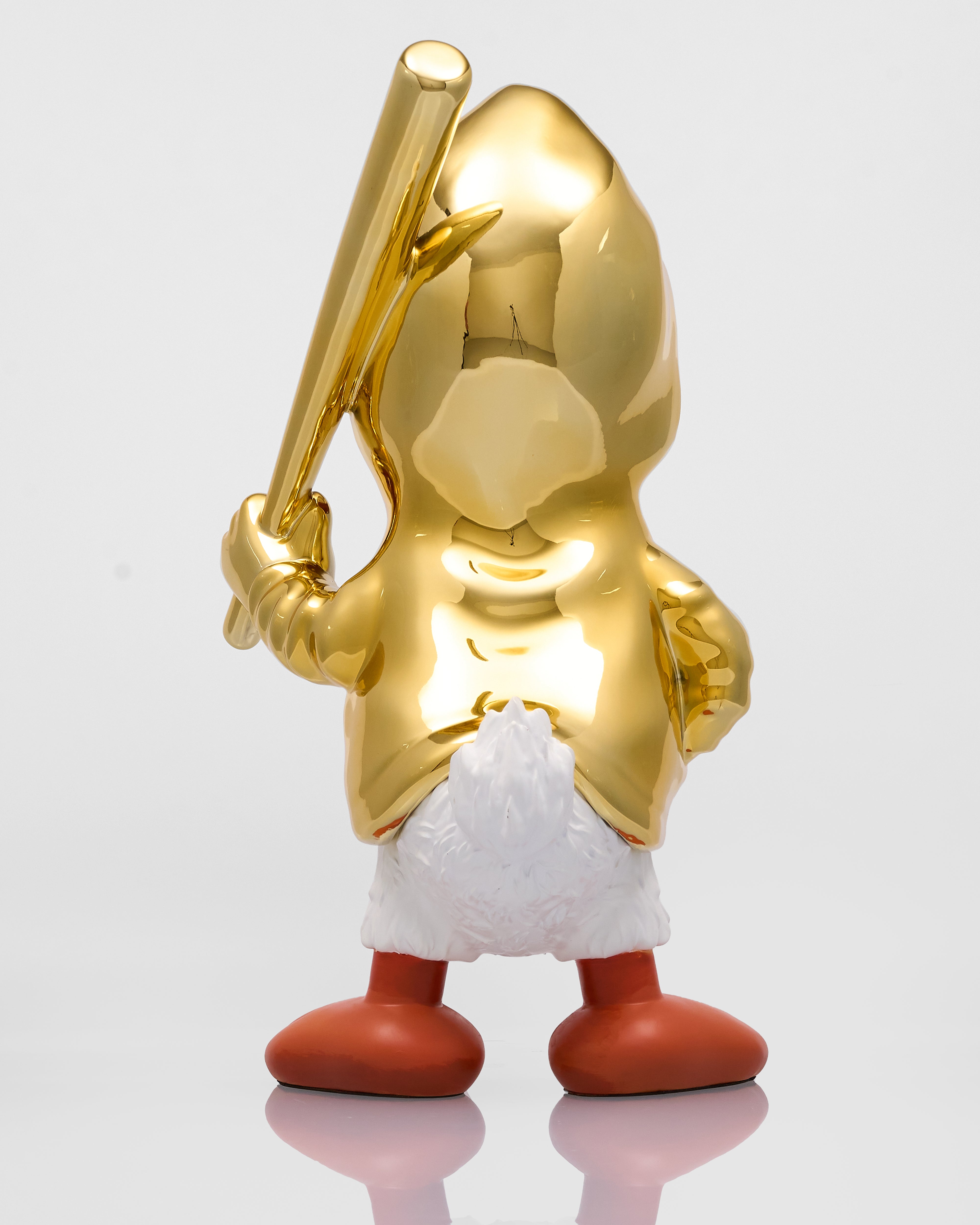 Gold-colored duck character with a baseball bat and red shoes on a reflective surface