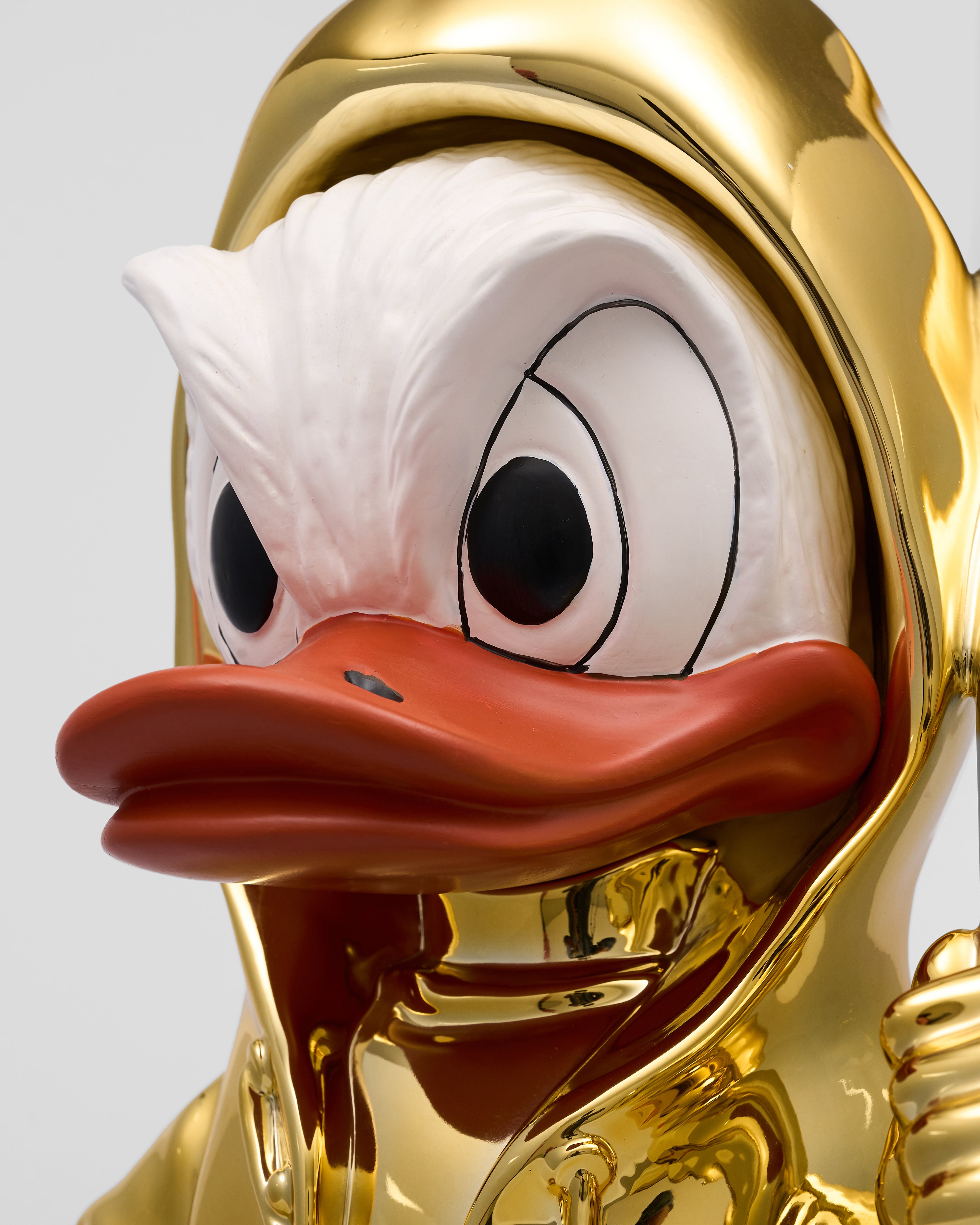 Gold-plated Donald Duck figurine with a white background