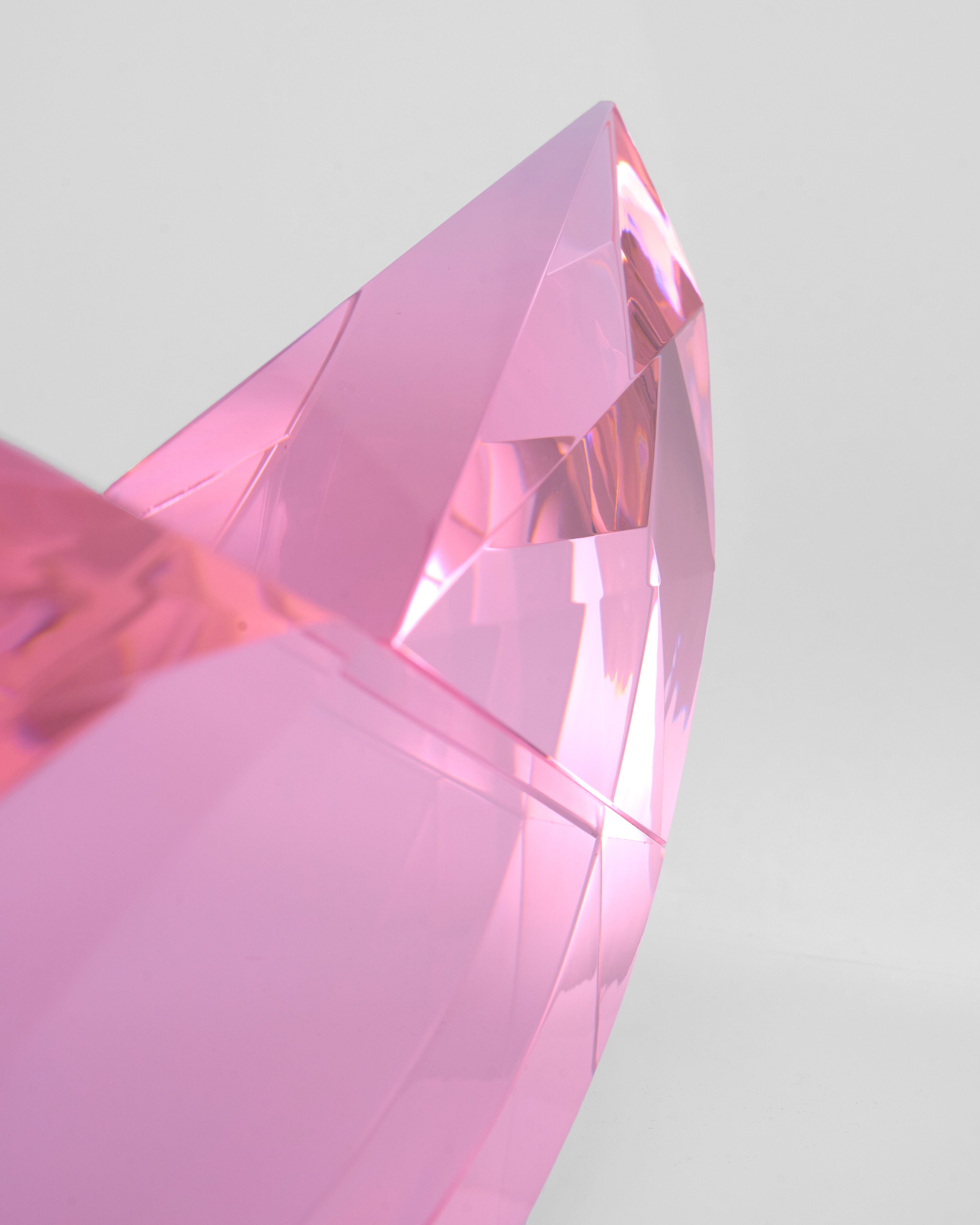 Close-up of a pink crystal prism on a light gray background