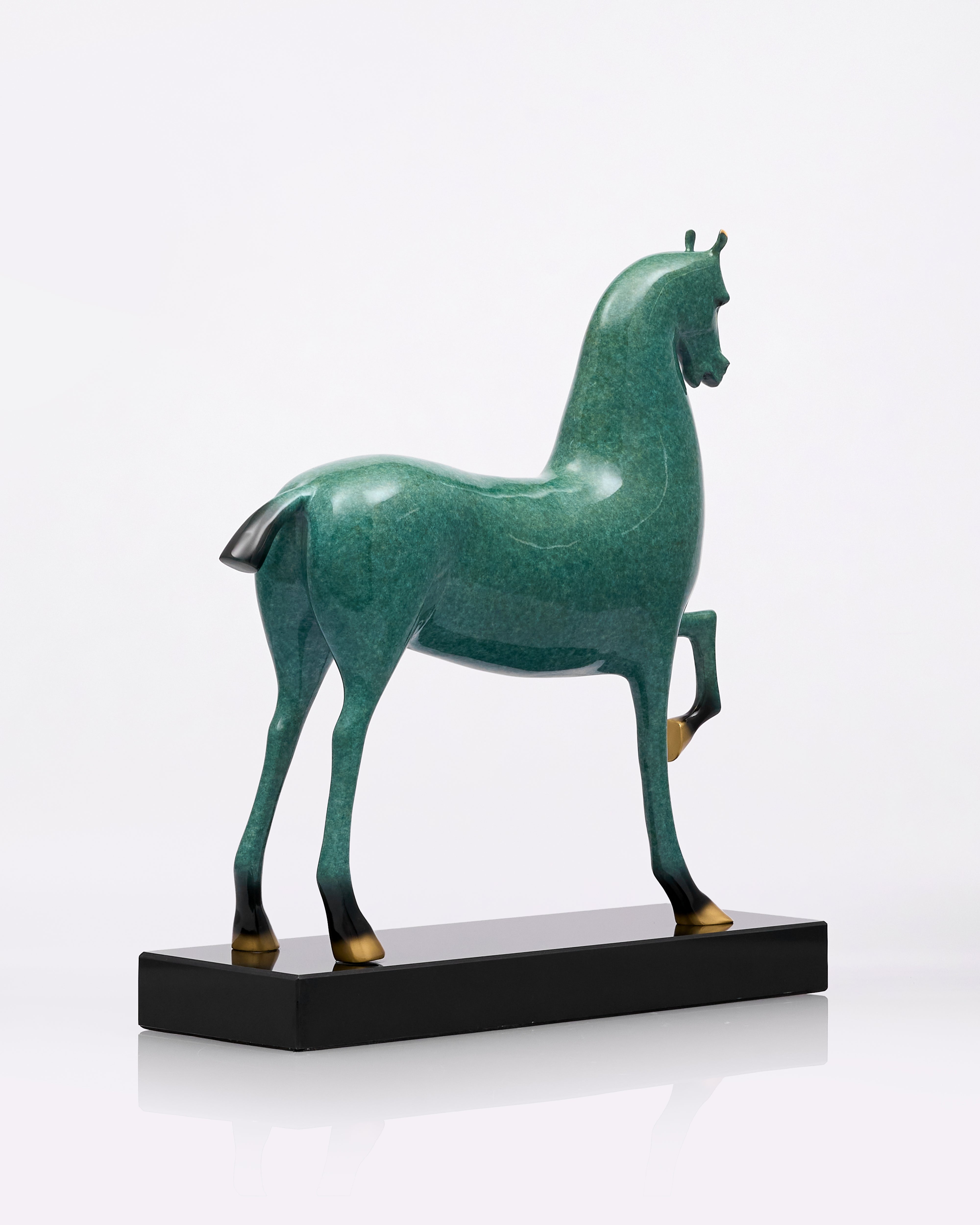Green horse sculpture on a black base against a white background