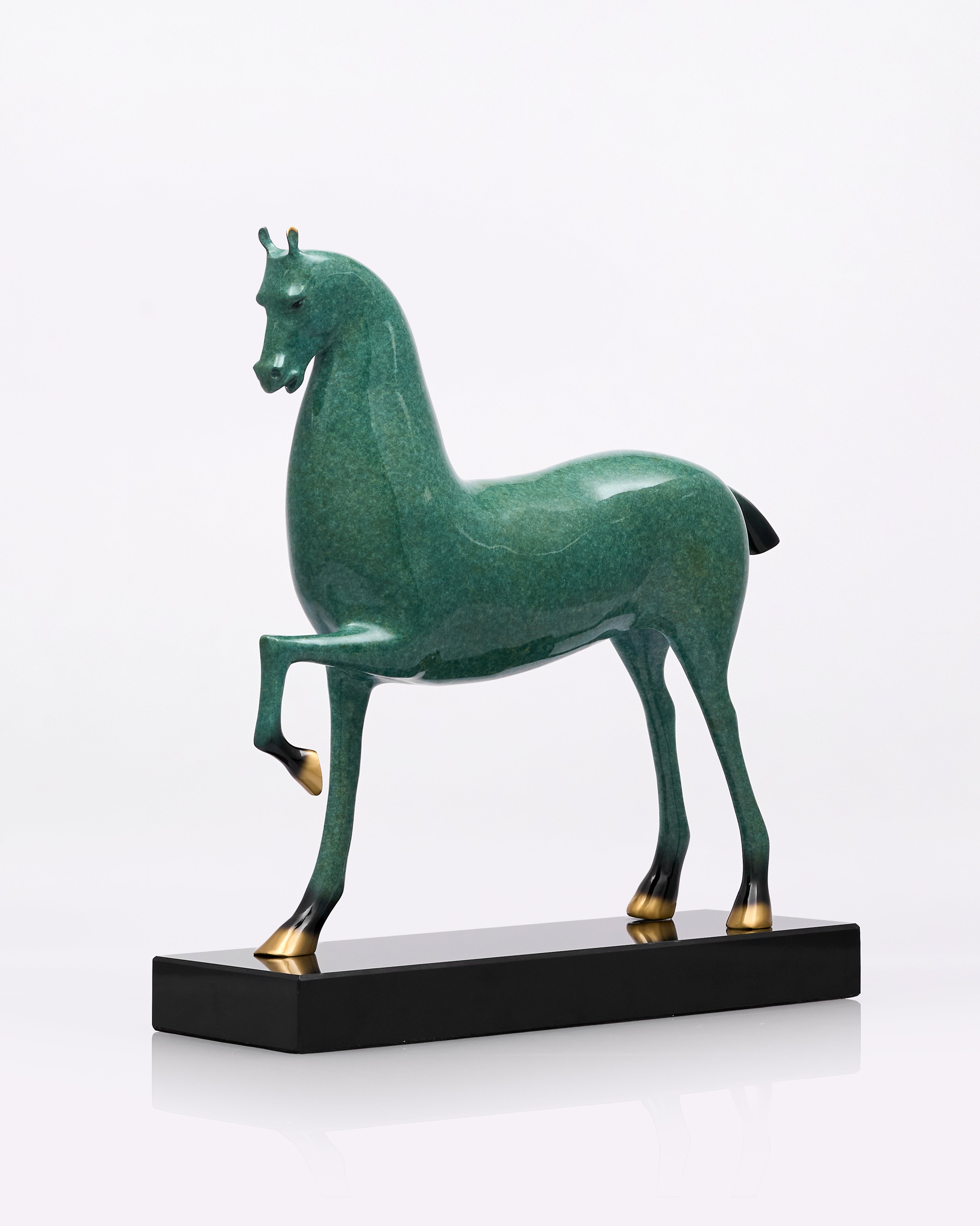Green horse sculpture on a black base against a white background