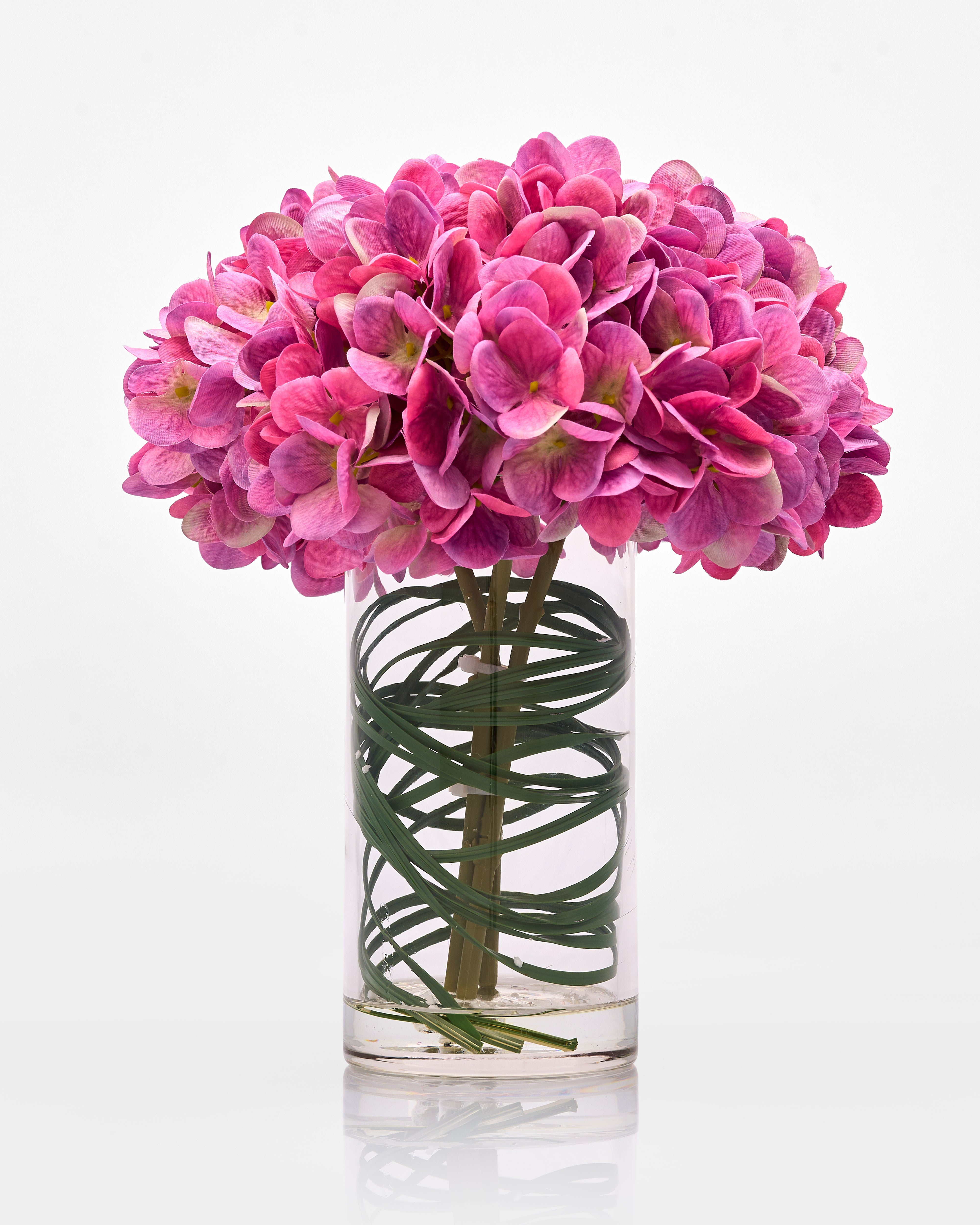 Clear glass vase with pink flowers on a white background