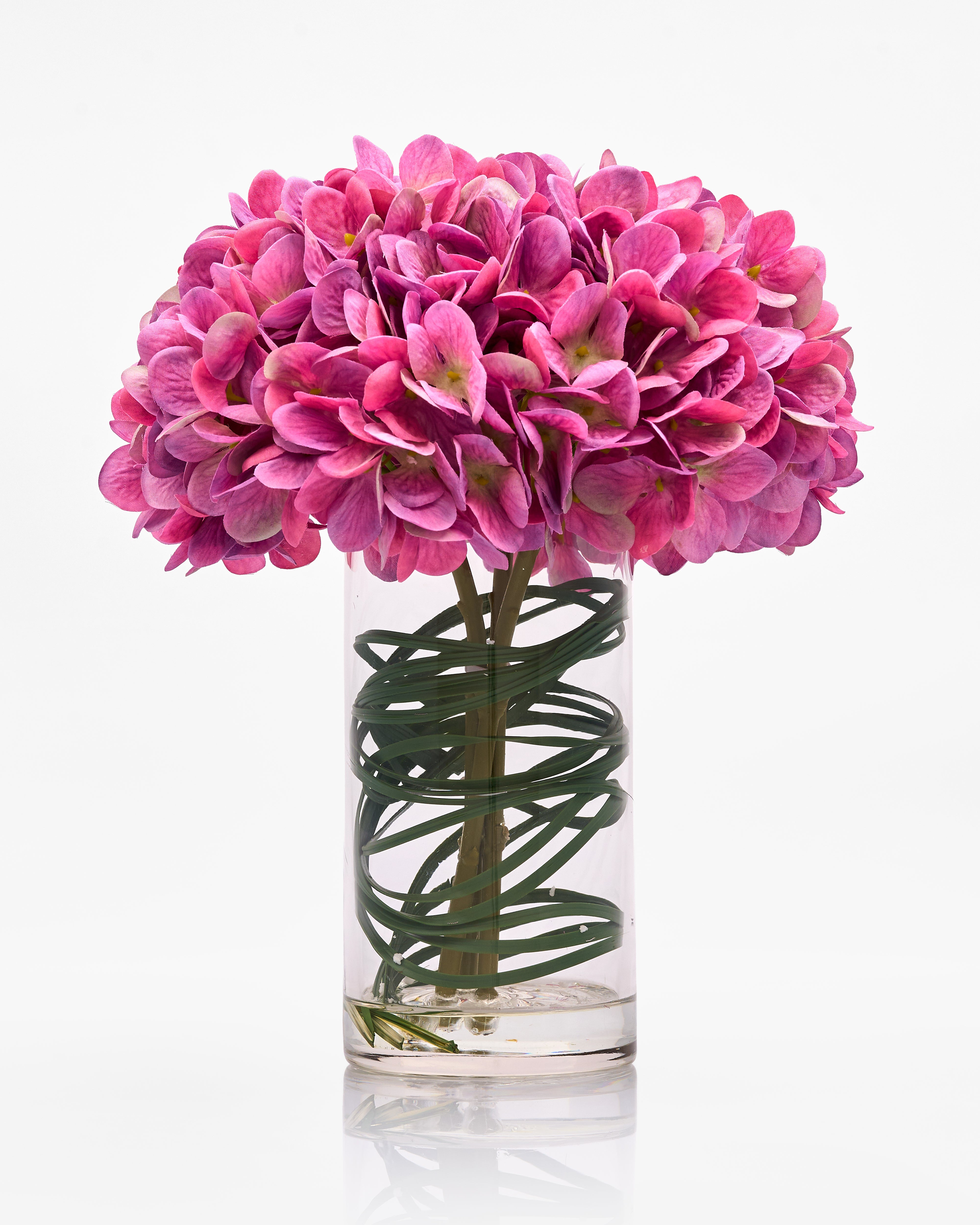 Pink flowers in a clear vase on a white background