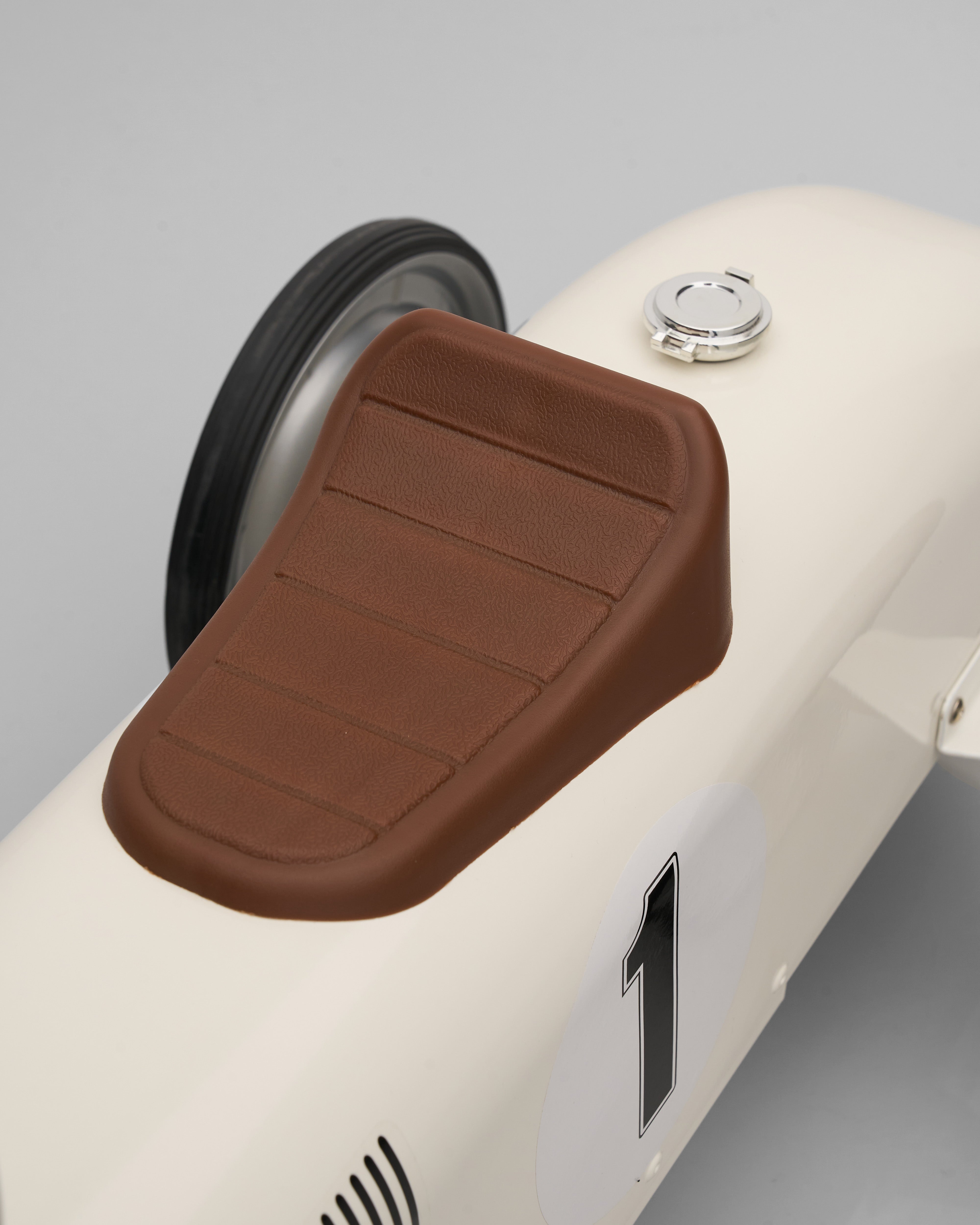 Brown seat cover on a white scooter with a gray background