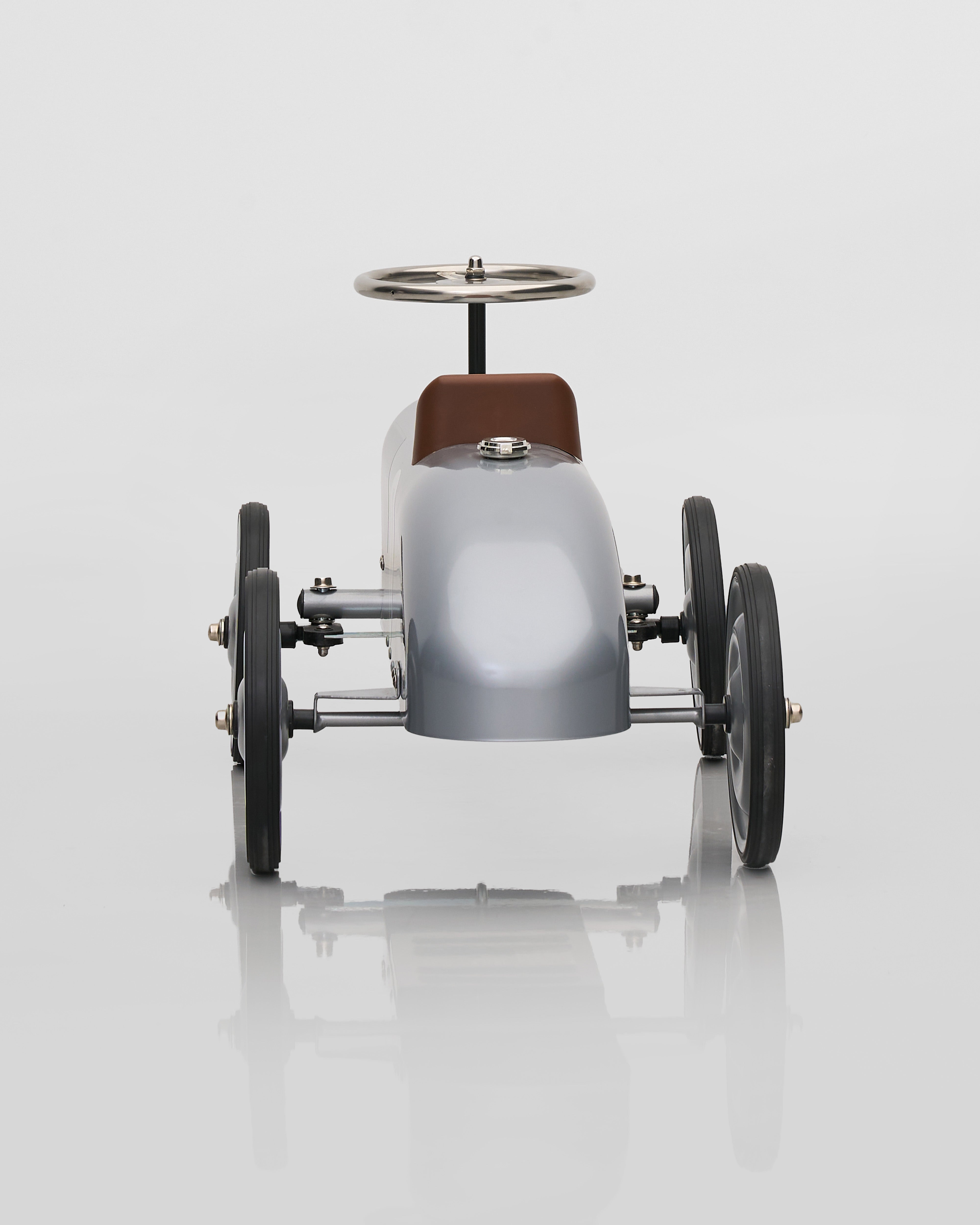 Children's toy car with a silver body and brown seat on a white background