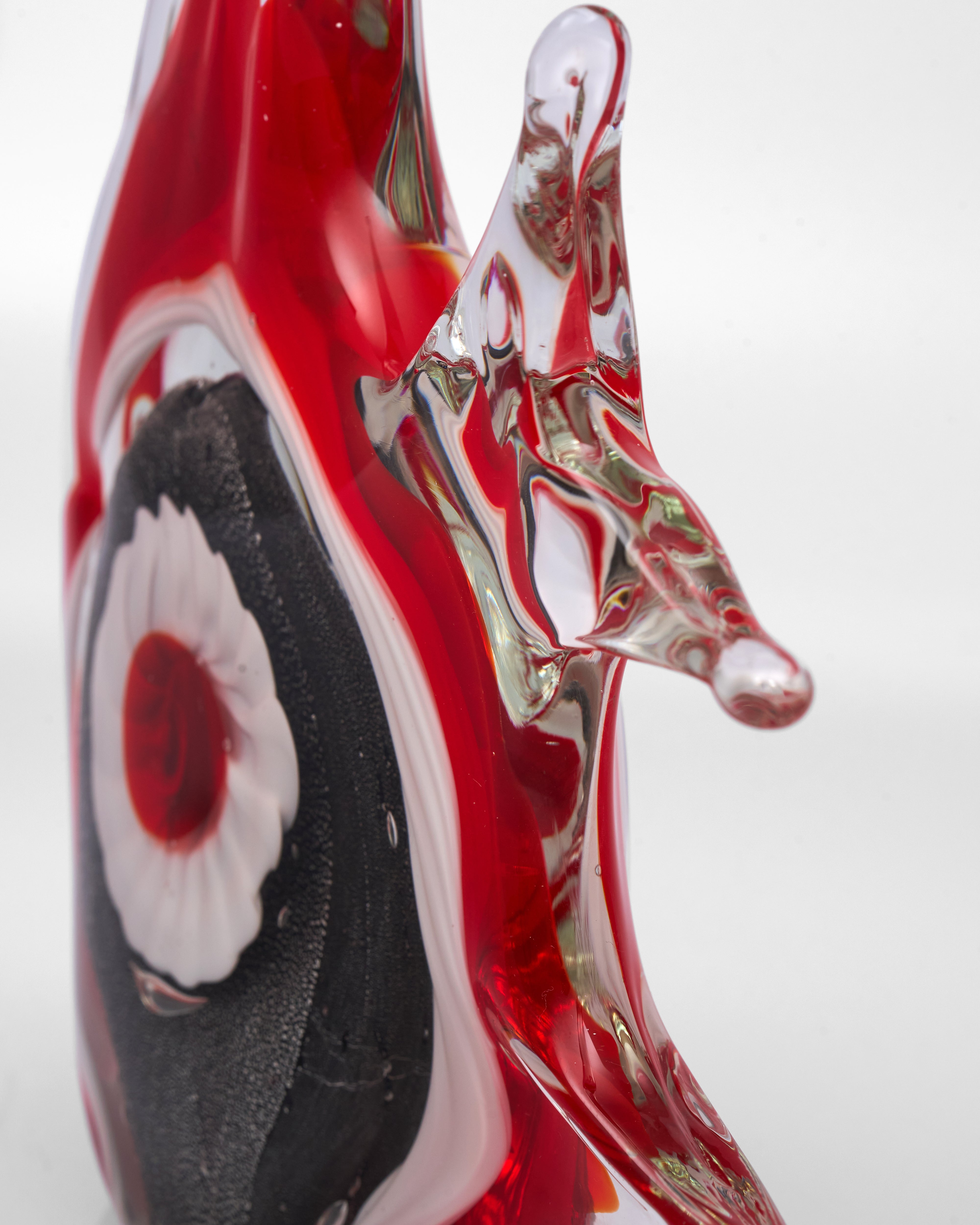 Glass sculpture with red, black, and white colors on a white background