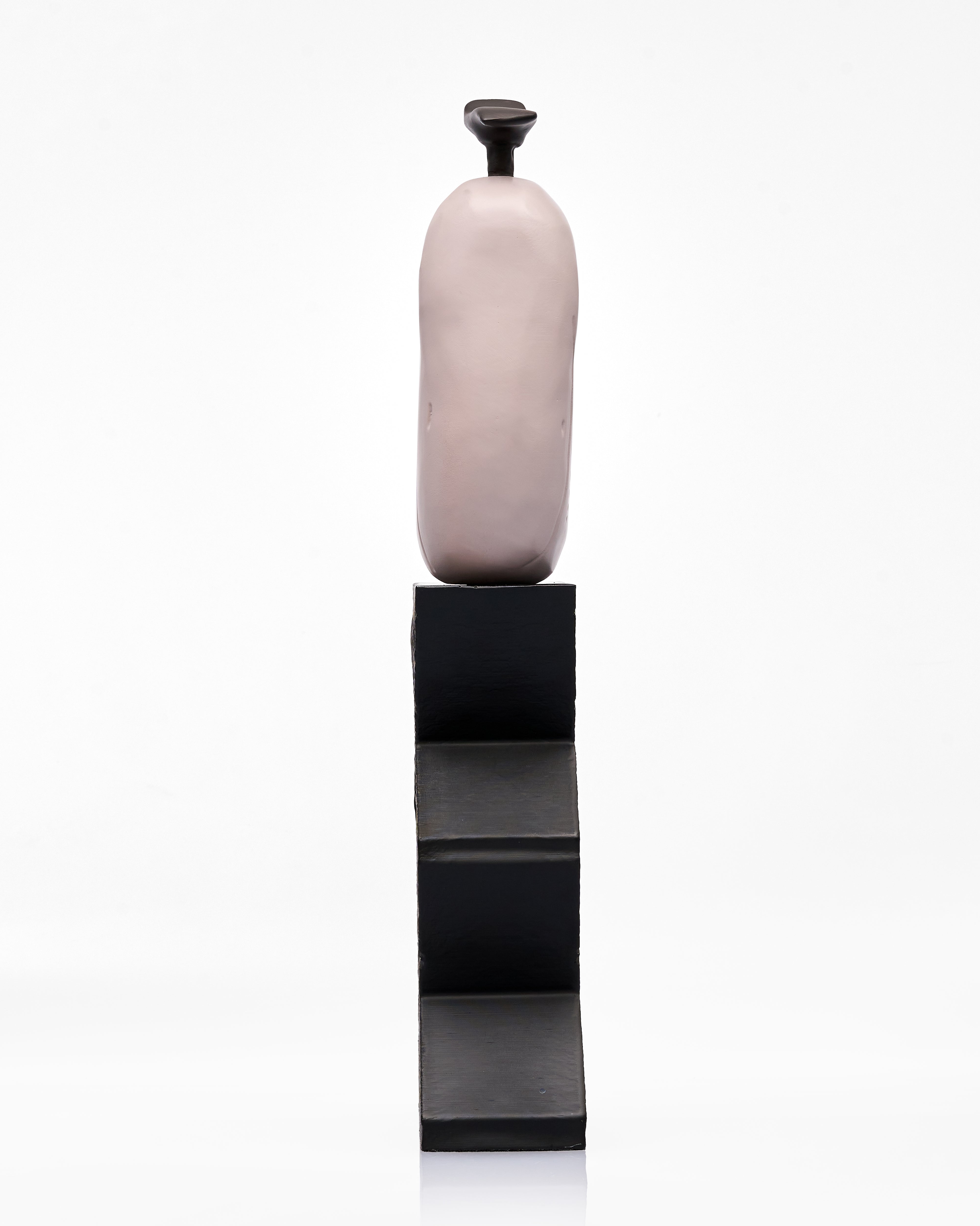 pink wooden vase on a black stand against a white background