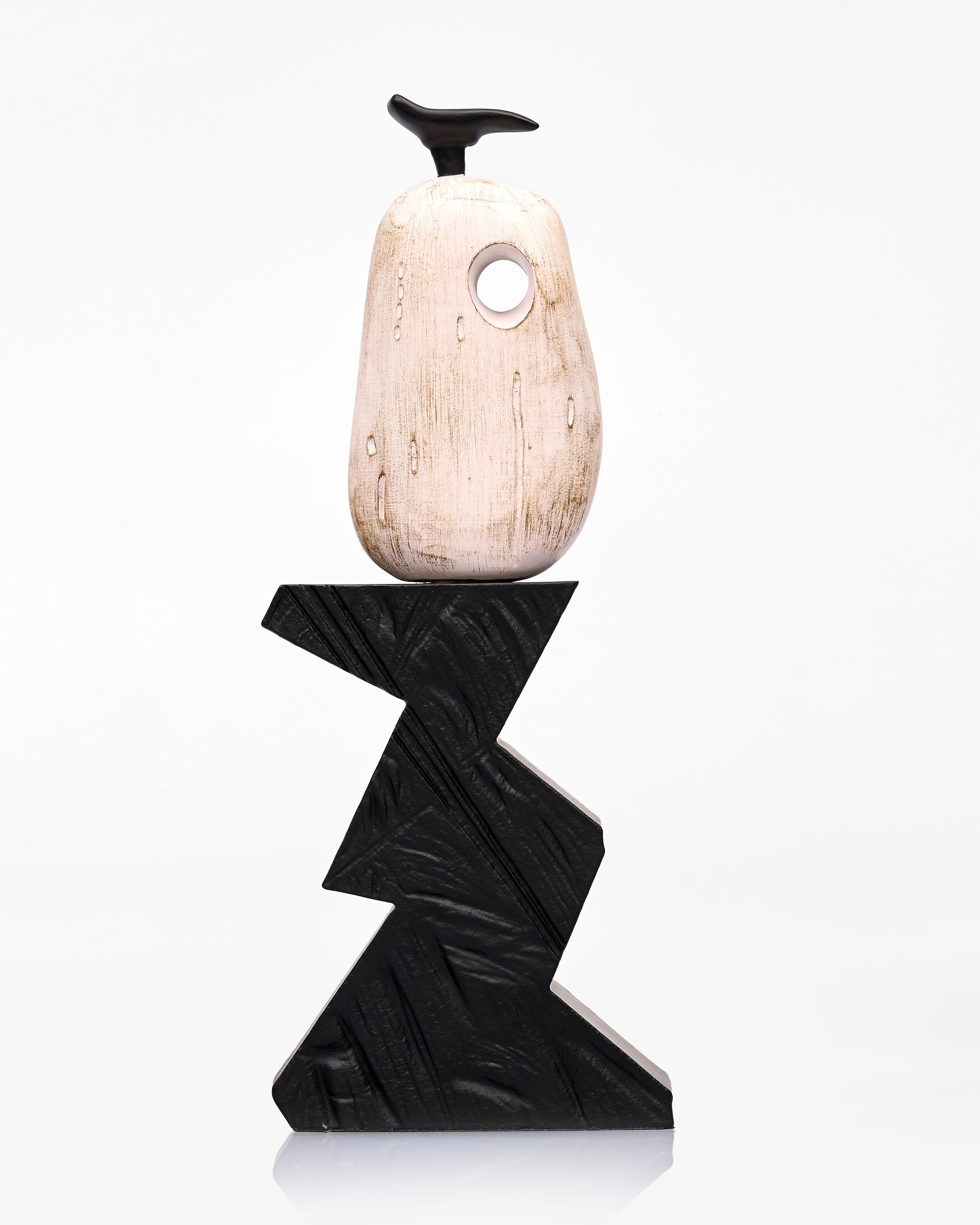 Decorative object with a black zigzag base and a beige top on a white background