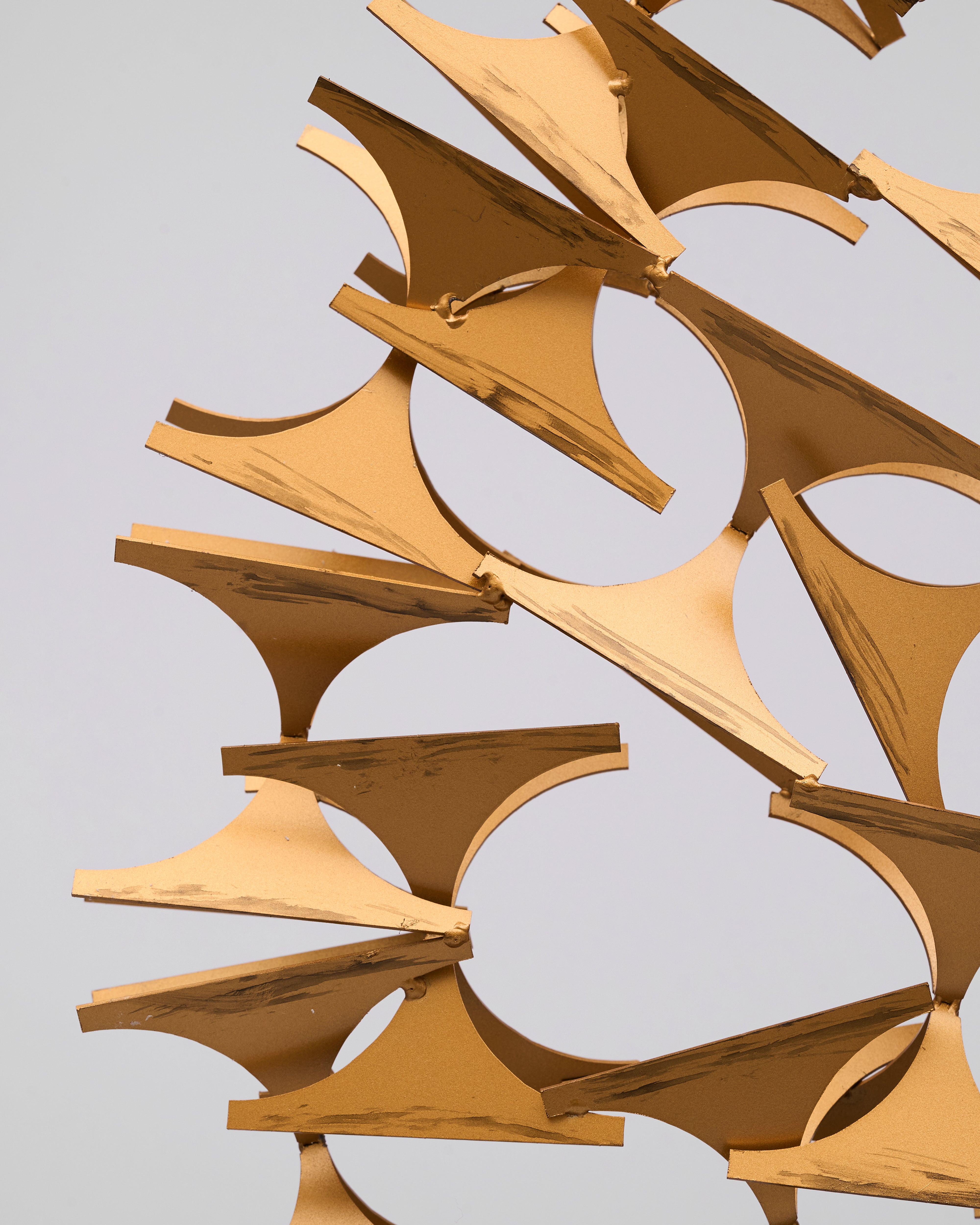 Gold abstract sculpture on a gray background