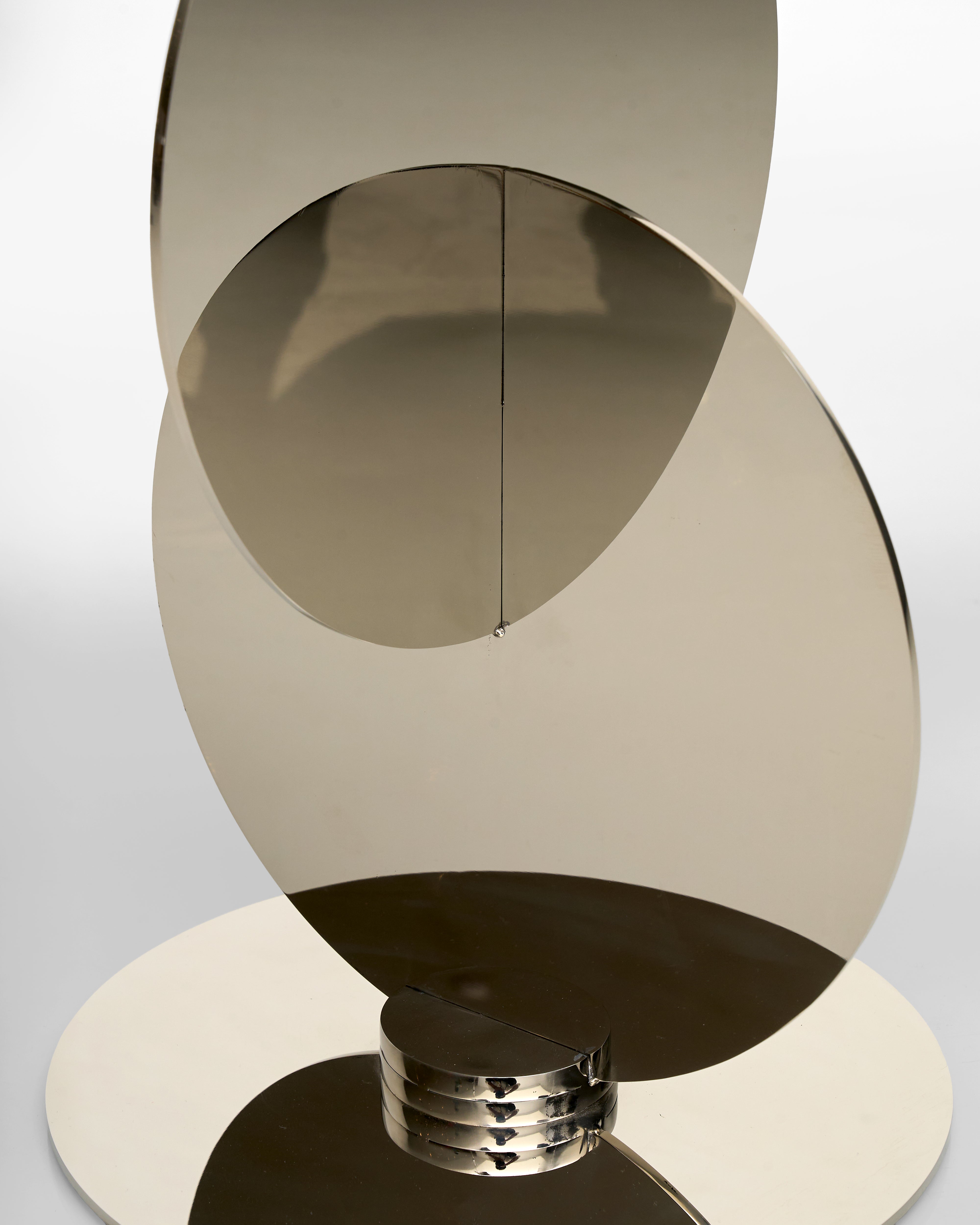 silver colored decorative object with a geometric design on a light gray background