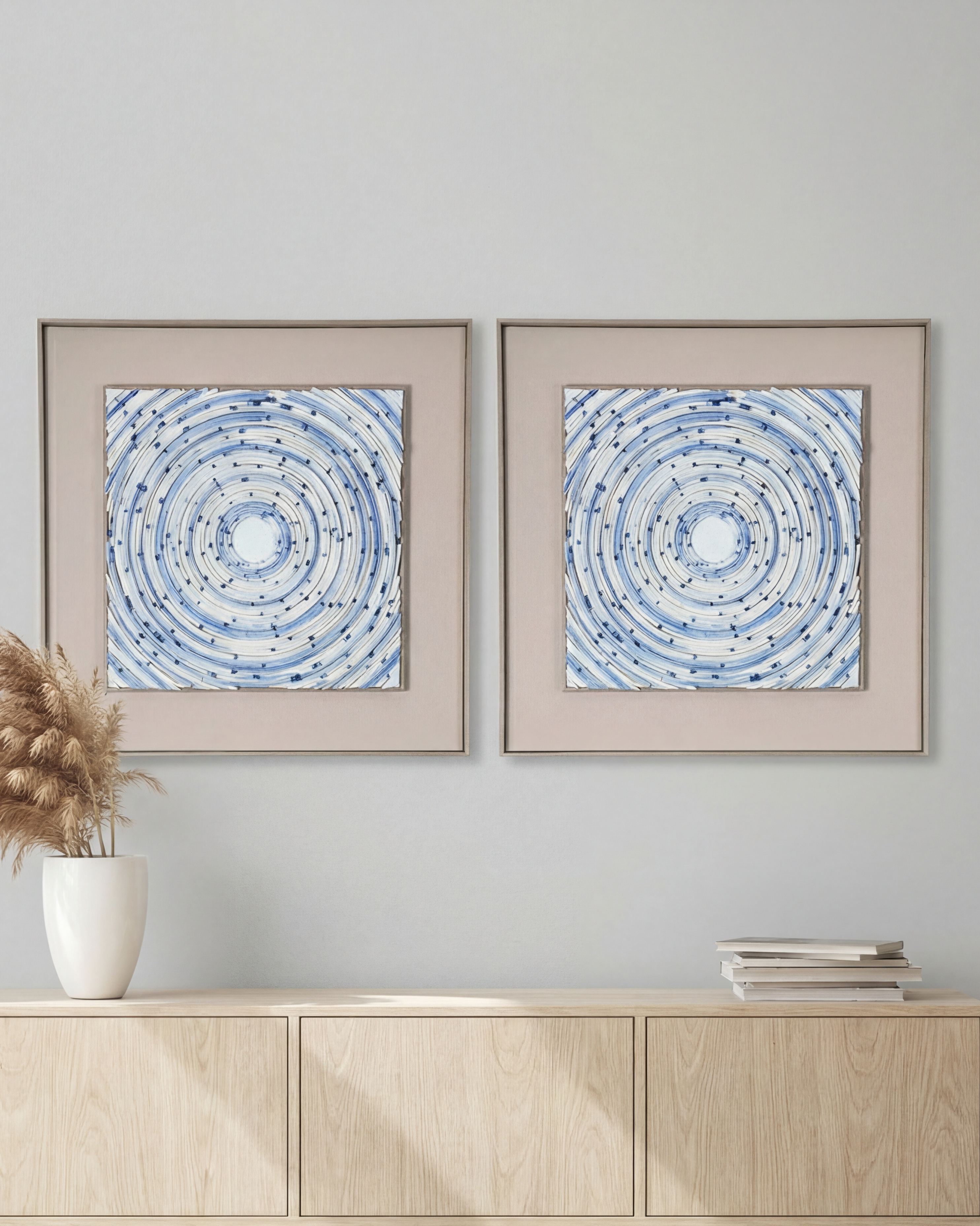 Two framed abstract artworks on a wall above a wooden console table.