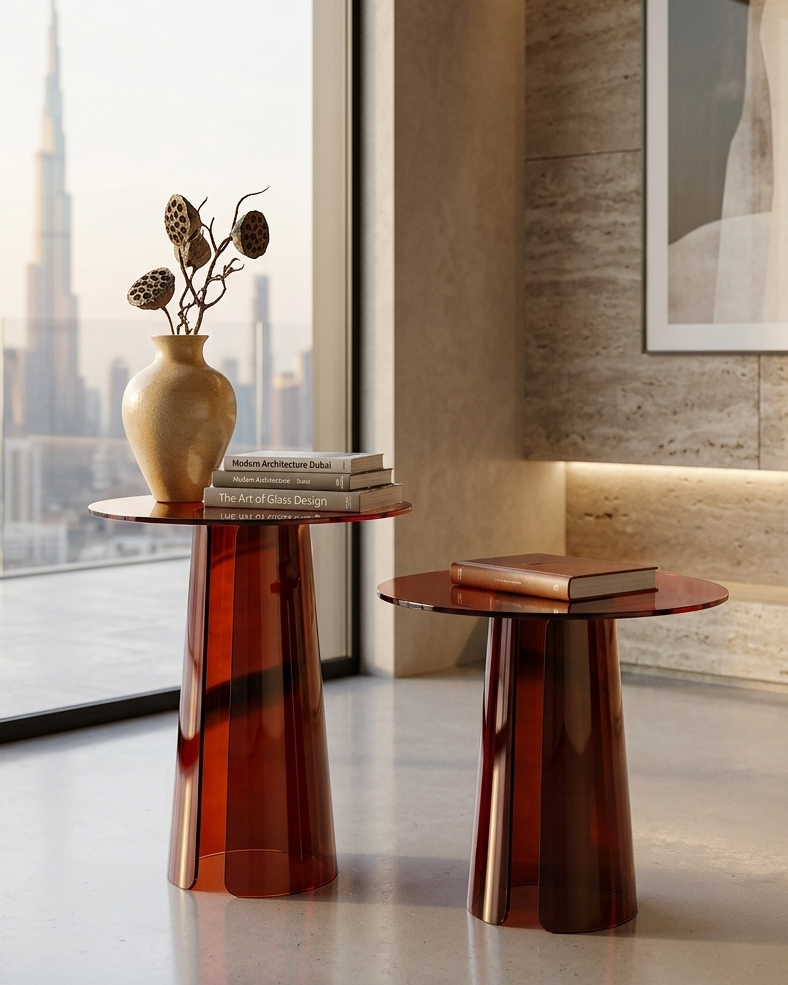 Two modern side tables with a vase and books in a room with large windows and abstract art.