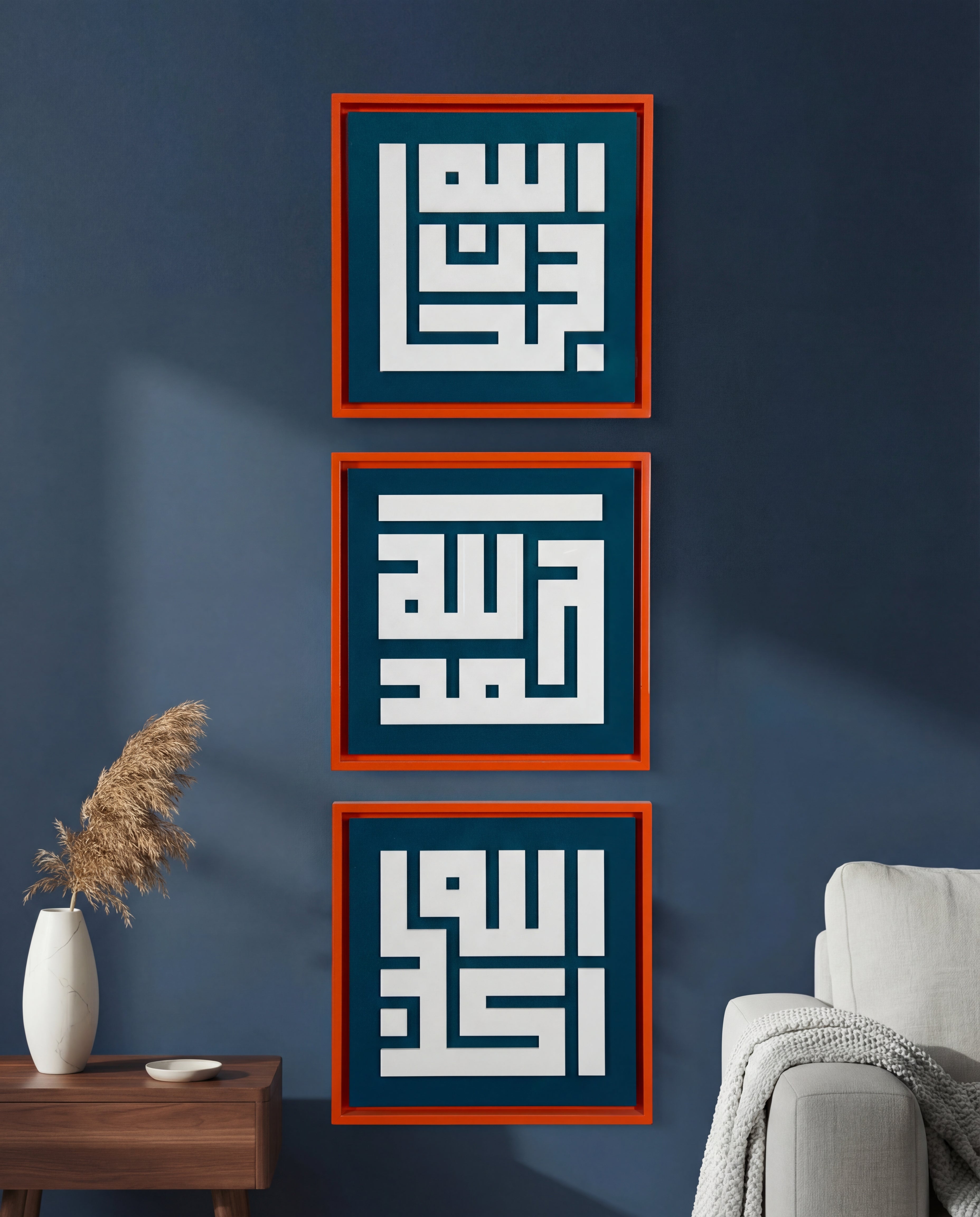 Three framed pieces of calligraphy art on a blue wall with a vase and chair in the foreground.