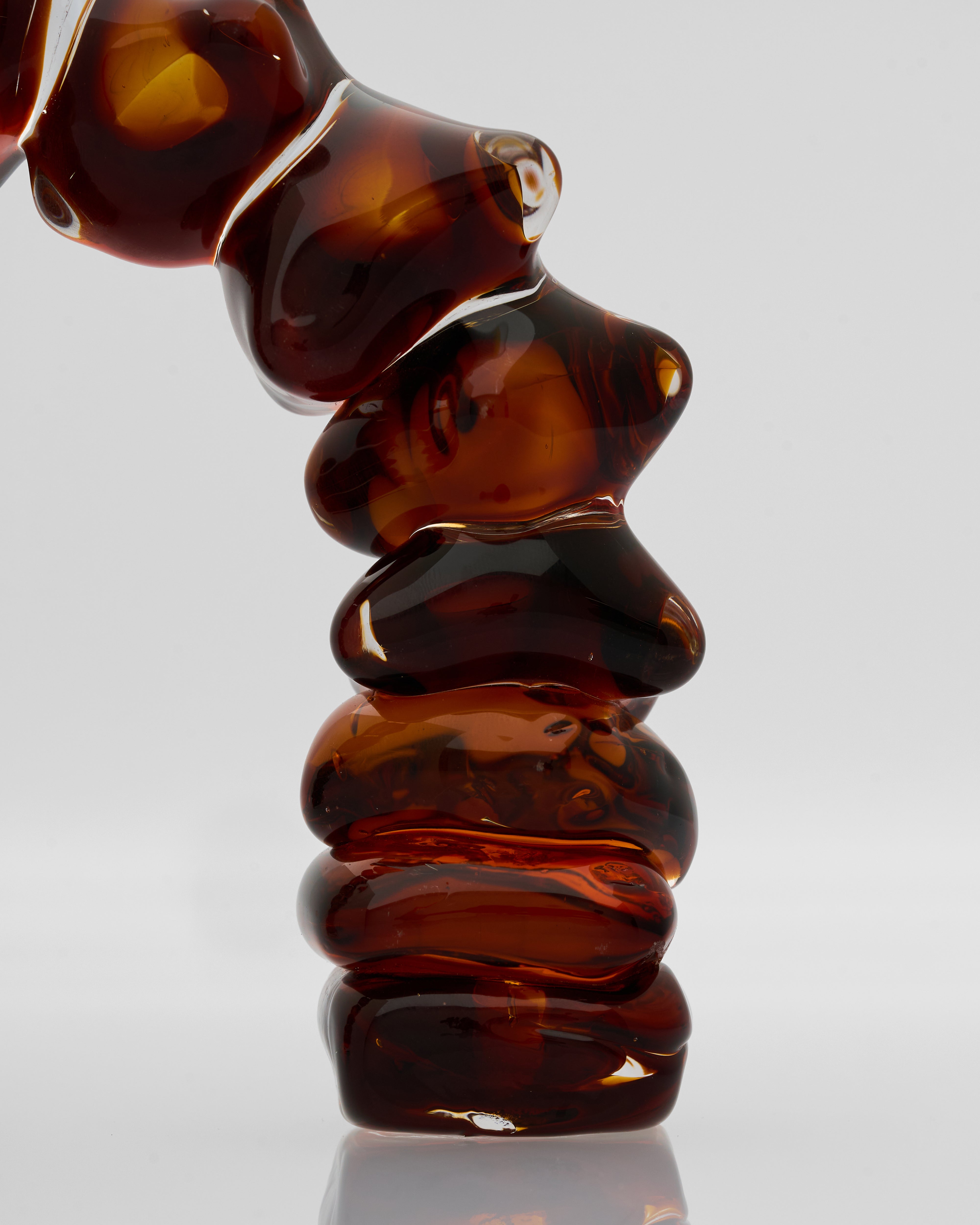 Close-up of a brown glass sculpture on a light gray background