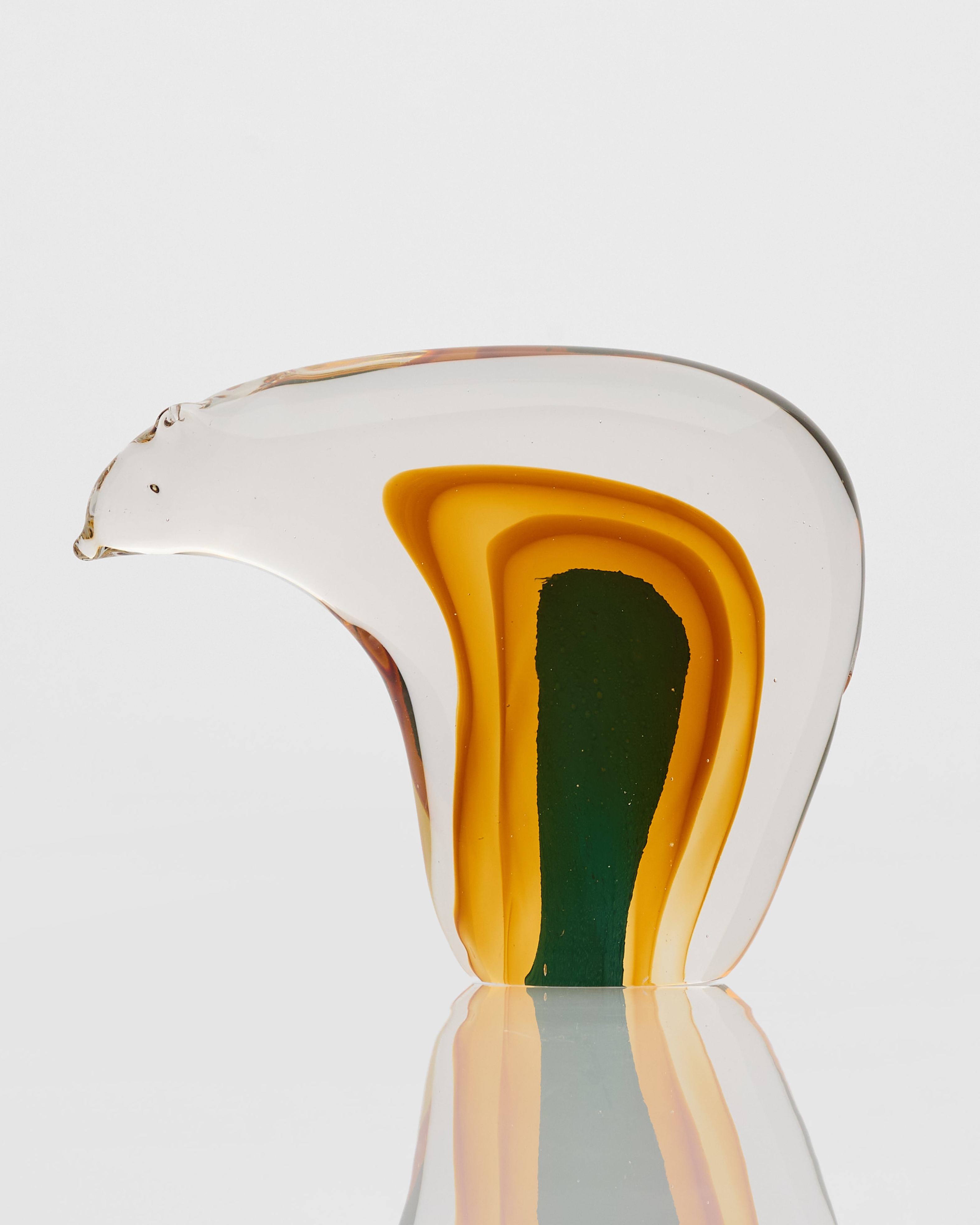 Glass sculpture with layered colors on a white background