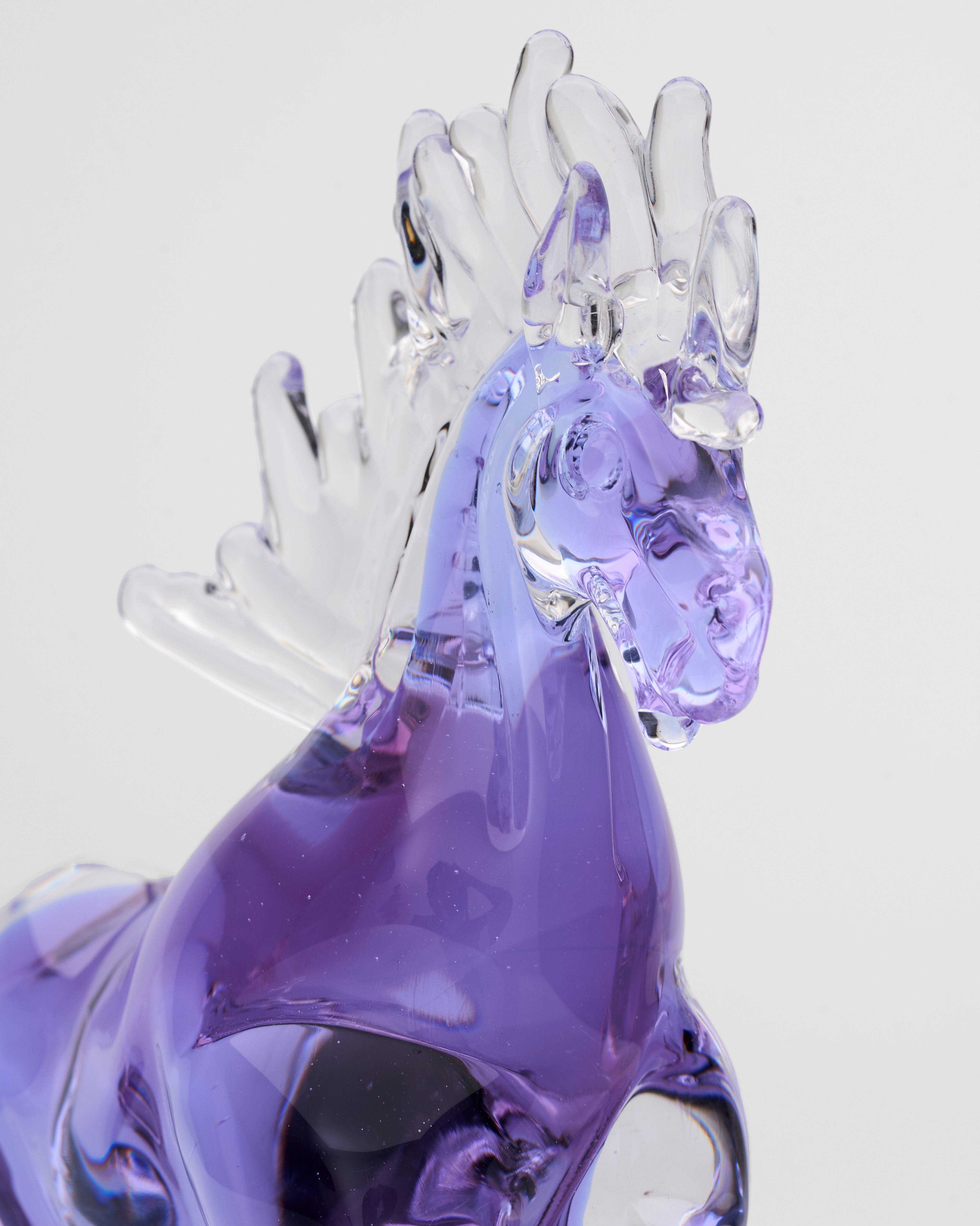 Purple glass rooster figurine on a white background