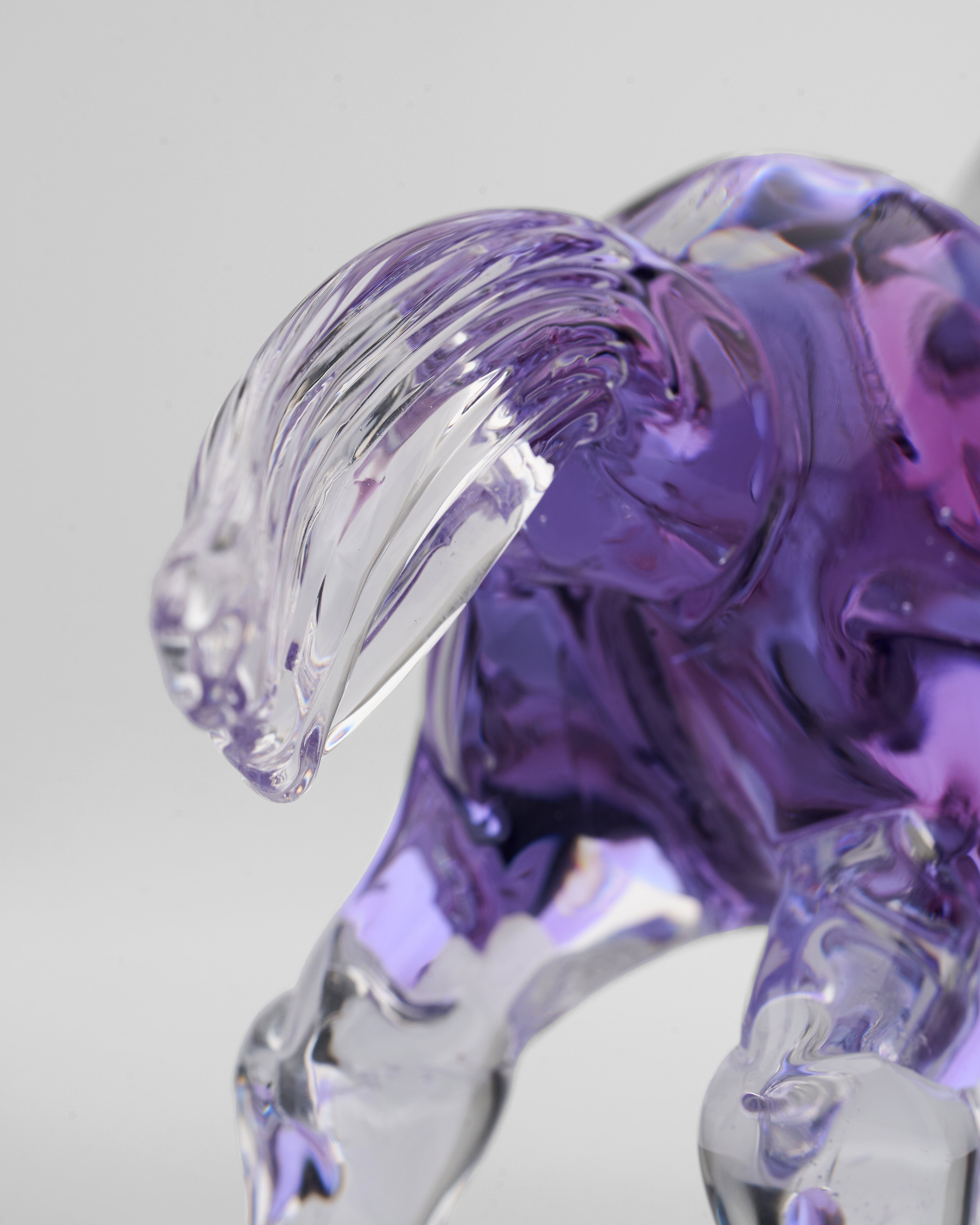 Purple glass sculpture of a dog on a white background