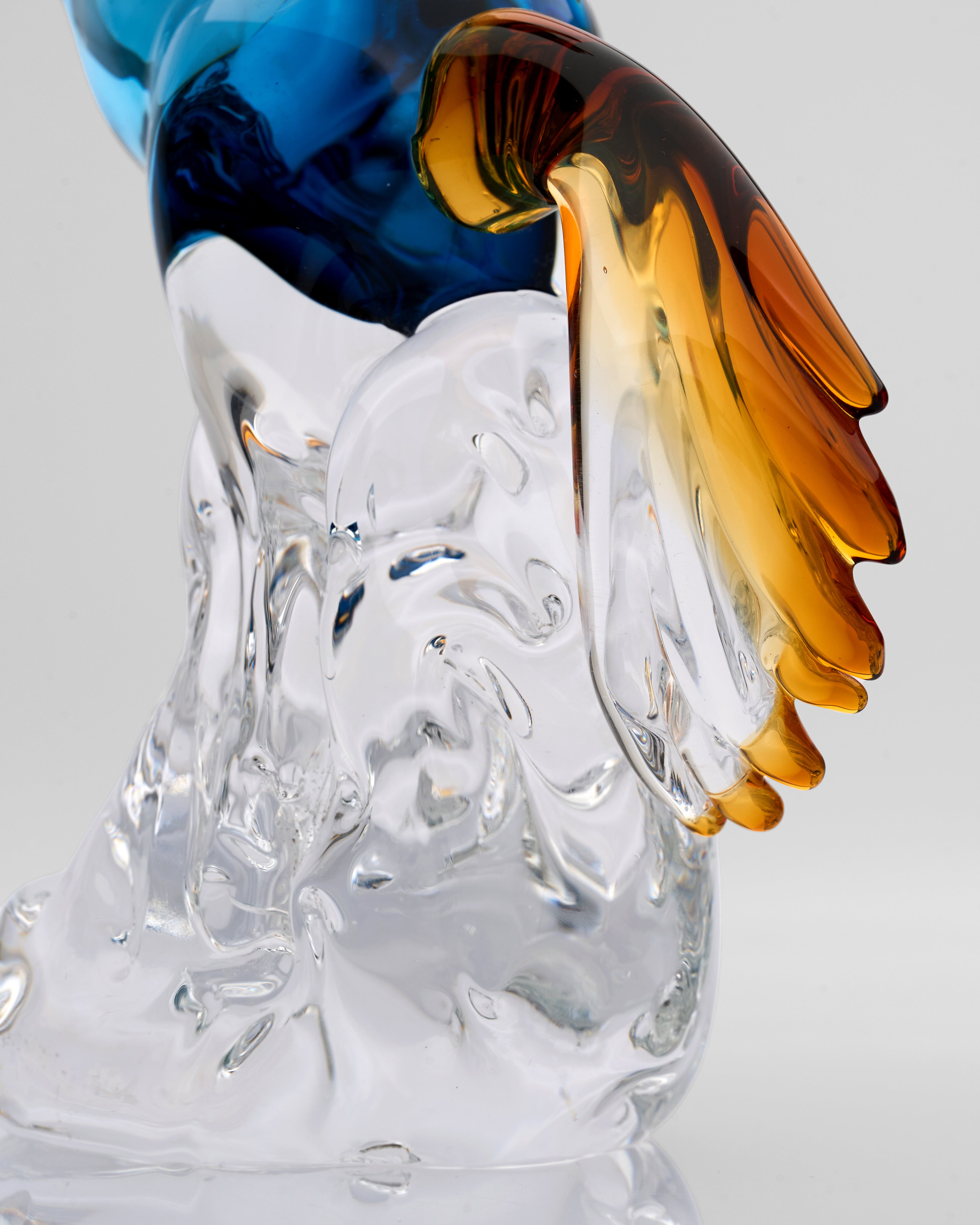 Glass sculpture with blue, amber, and clear colors on a gray background