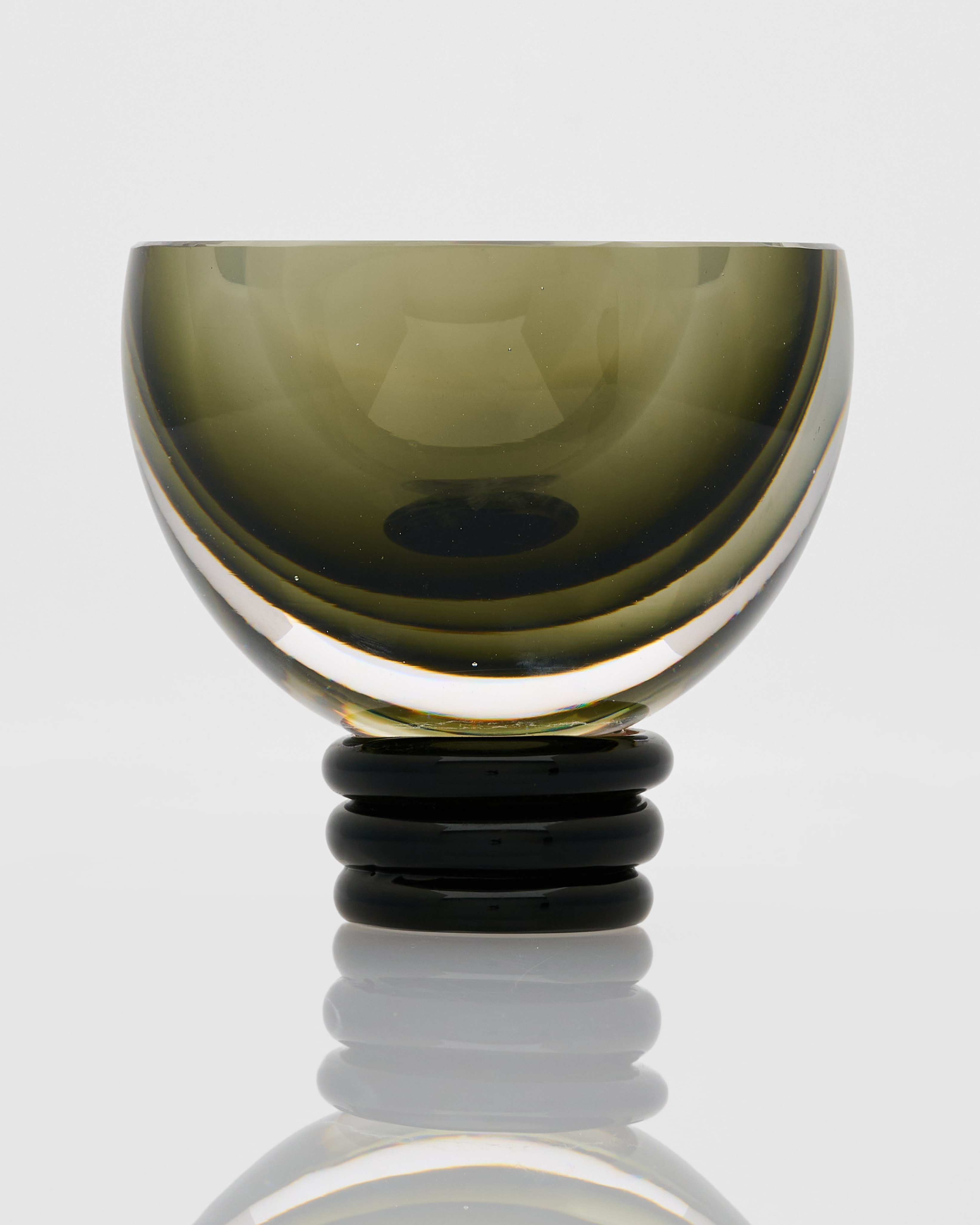 Contemporary green round vase luxury home accent with half-cut form and sculptural curly base design
