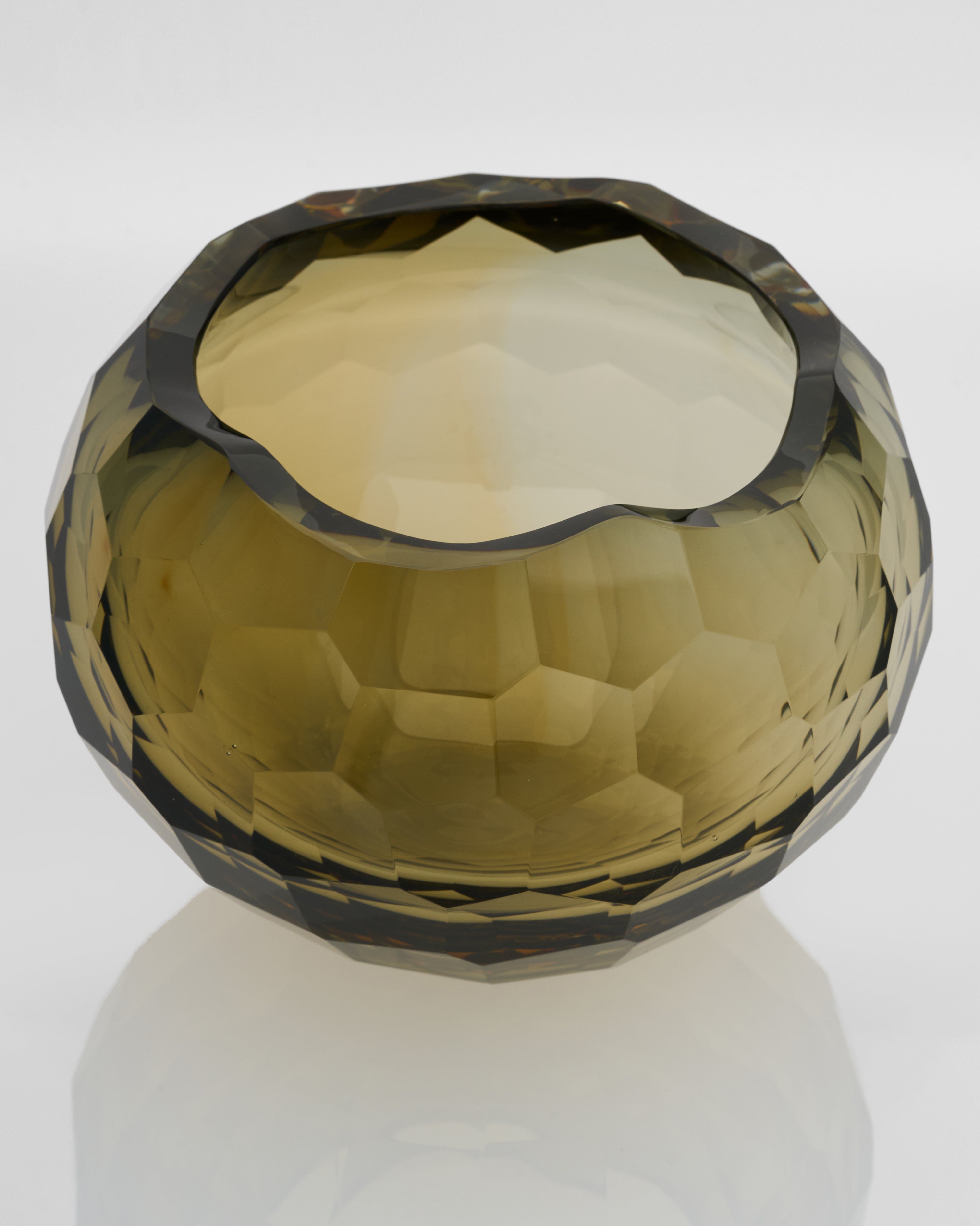 Faceted glass bowl with a greenish-brown color on a white background