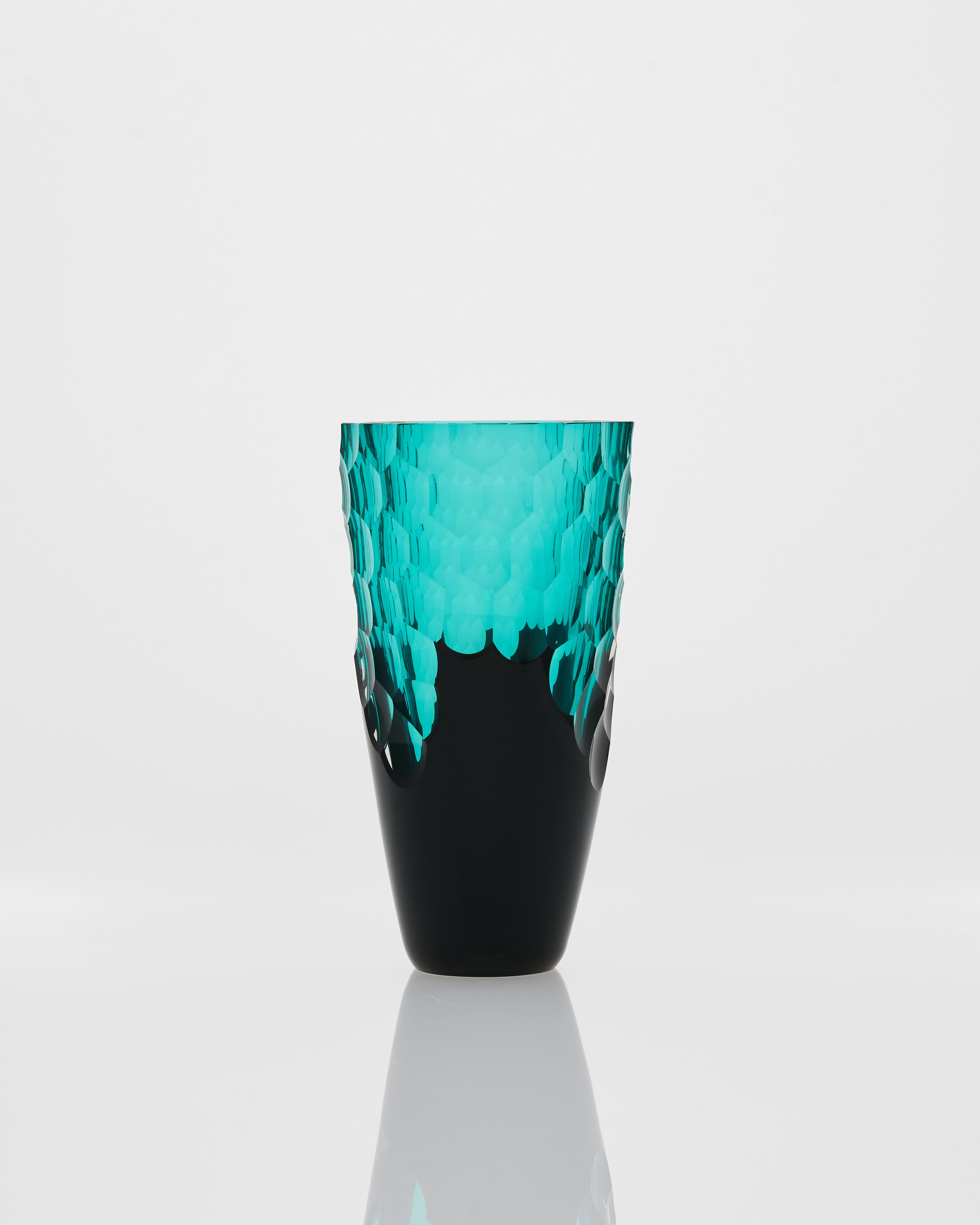 Turquoise and black textured vase on a white background