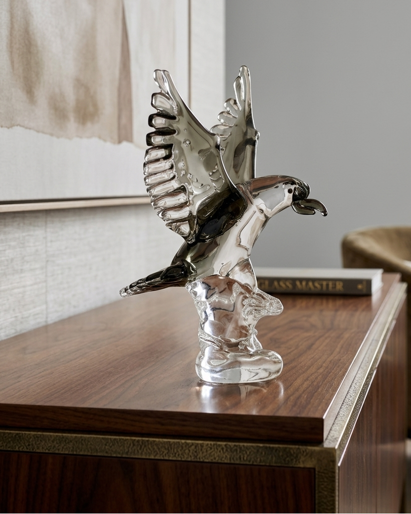 Crystal eagle figurine on a wooden surface with a neutral background