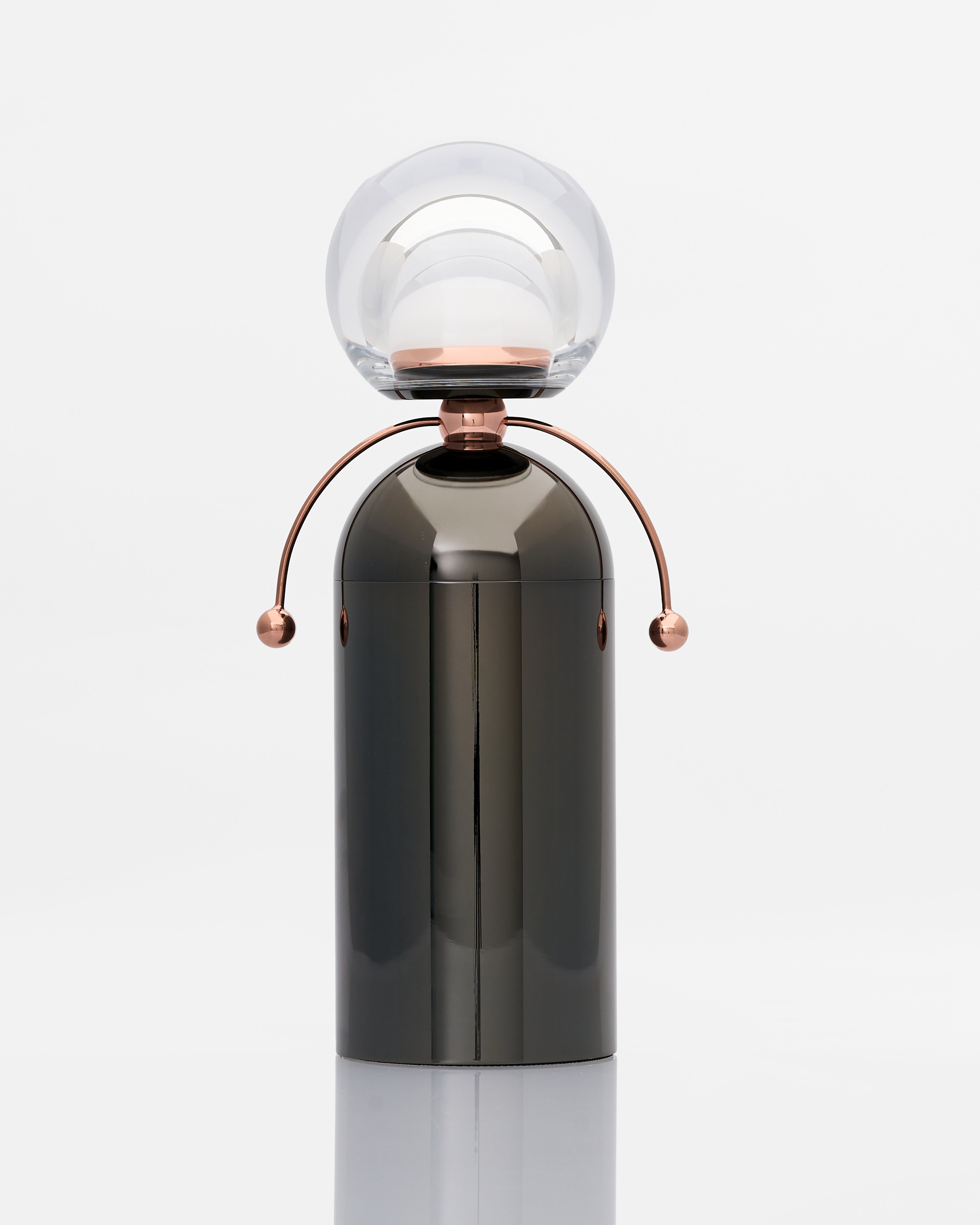 Modern lamp with a glass shade and metallic base on a white background