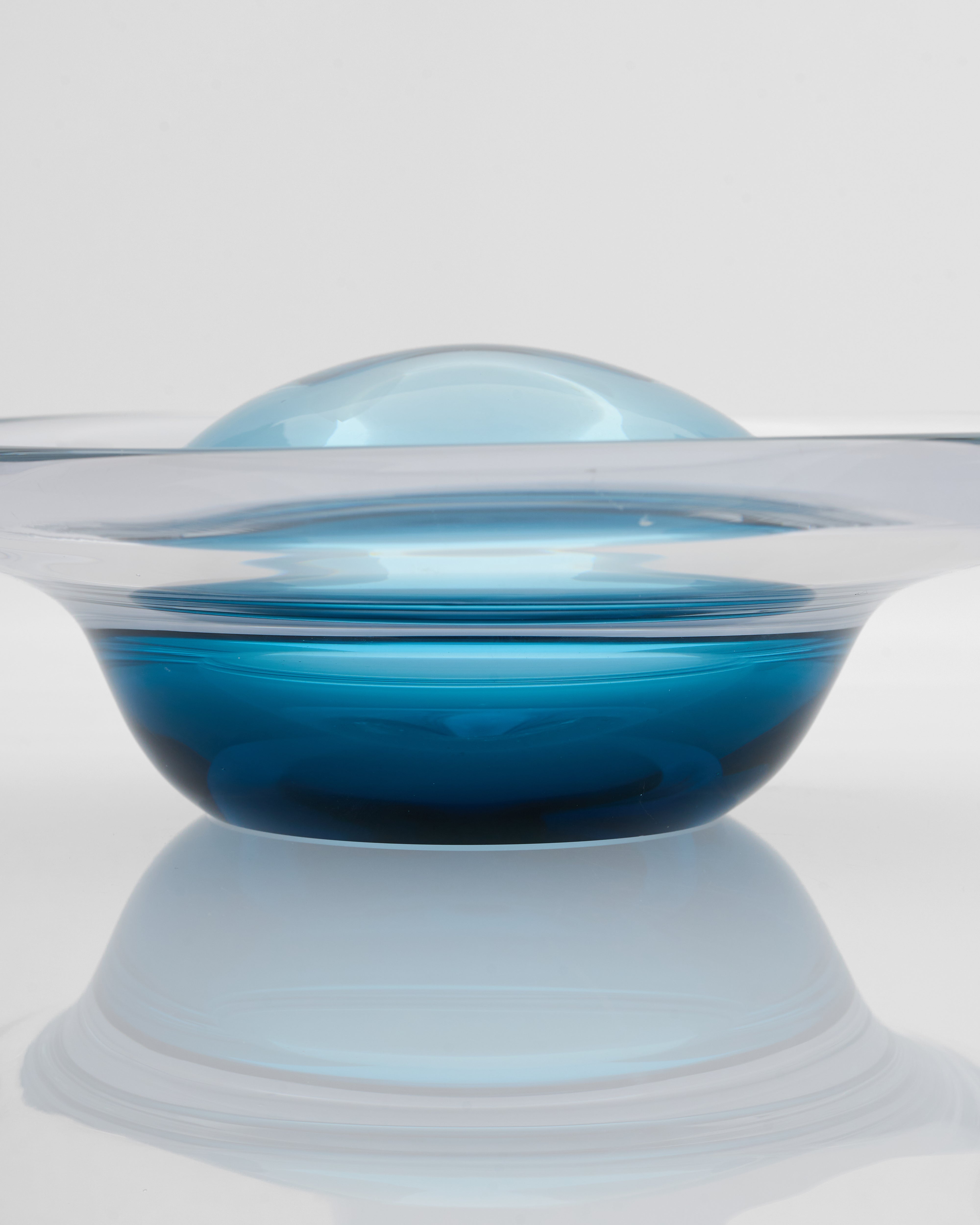 Glass bowl with blue liquid on a white background