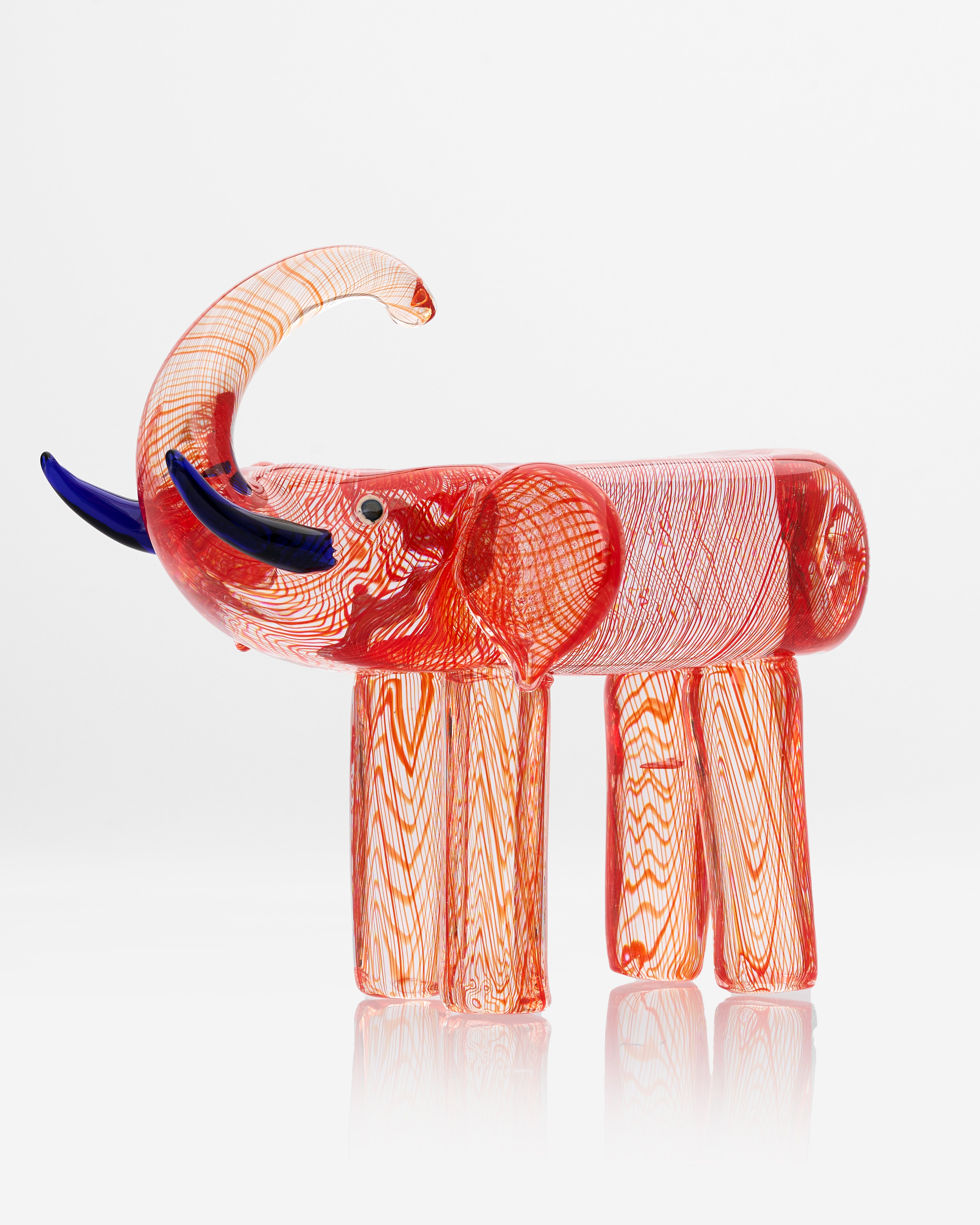 Glass elephant sculpture with red and orange patterns on a white background