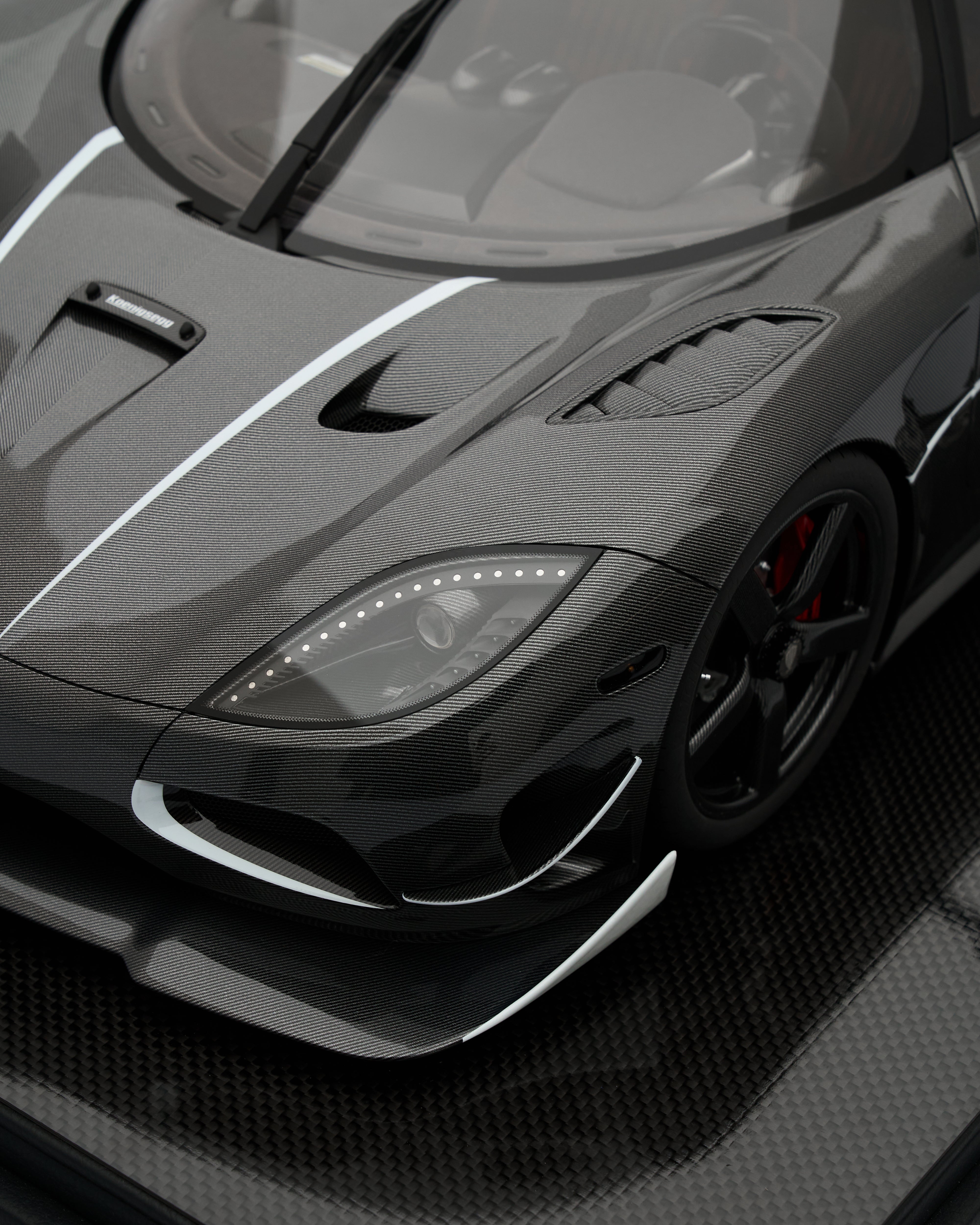 Close-up of a black sports car with carbon fiber texture