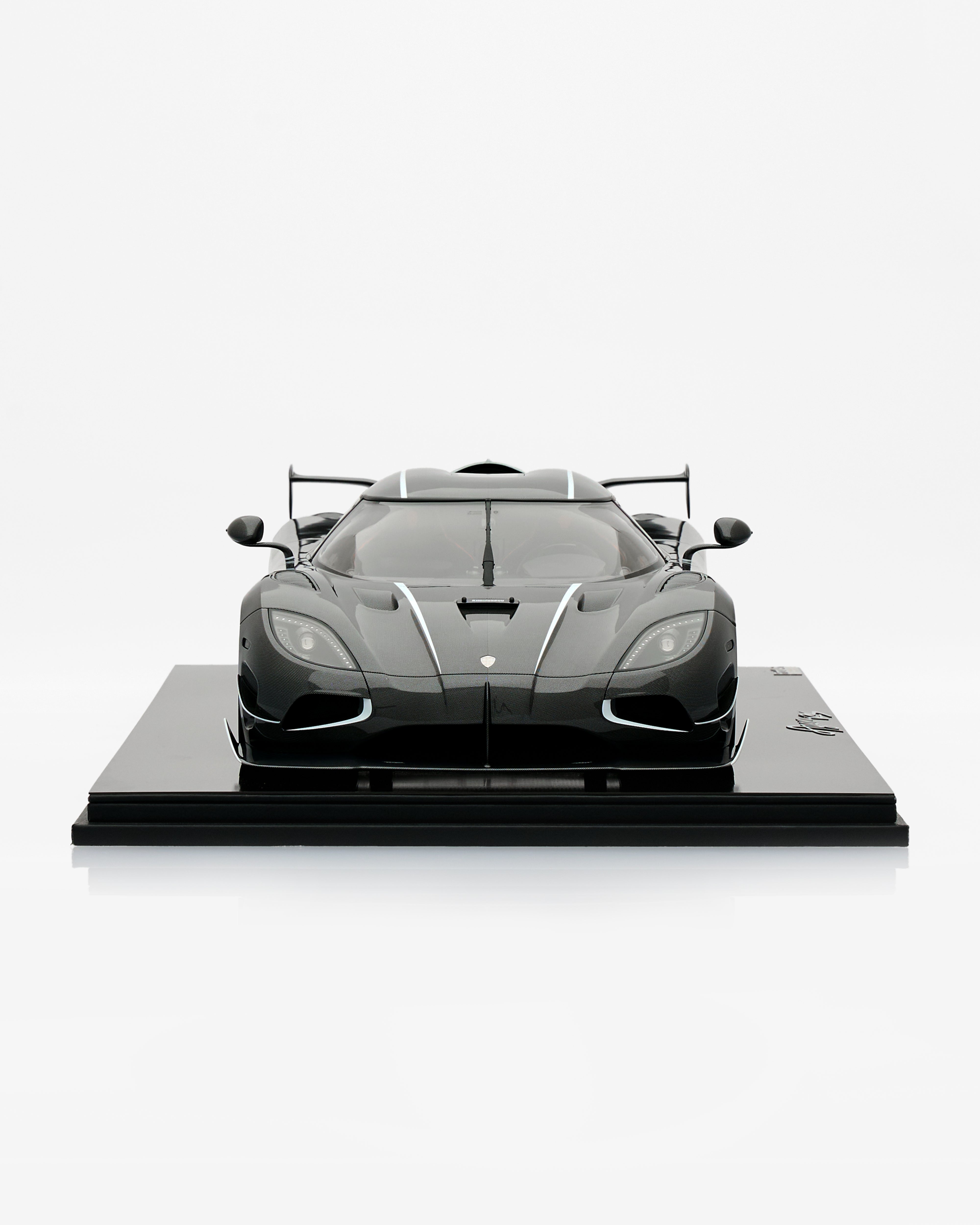 Model of a sports car on a black platform with a white background