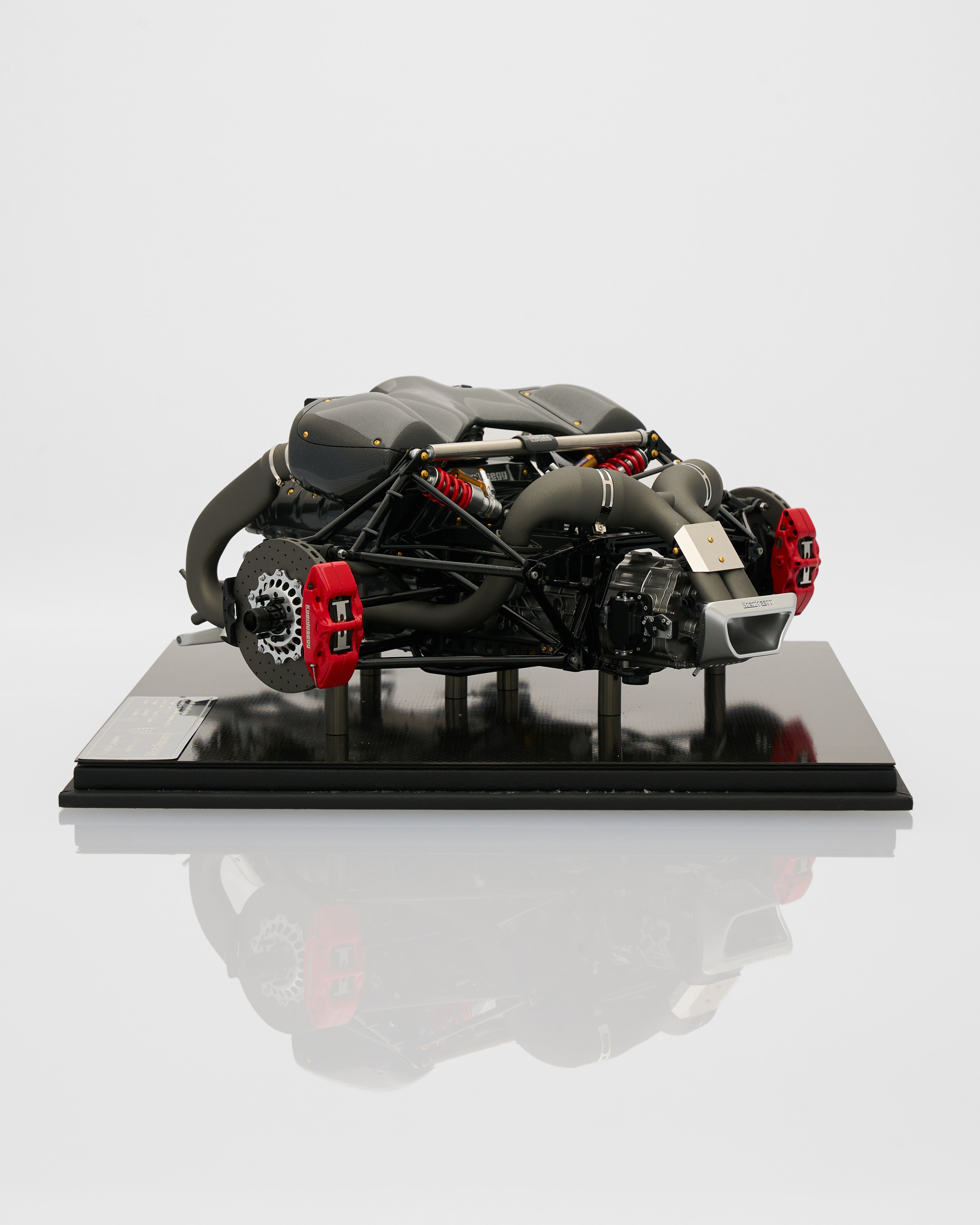 Model of a sports car chassis on a reflective surface with a light gray background
