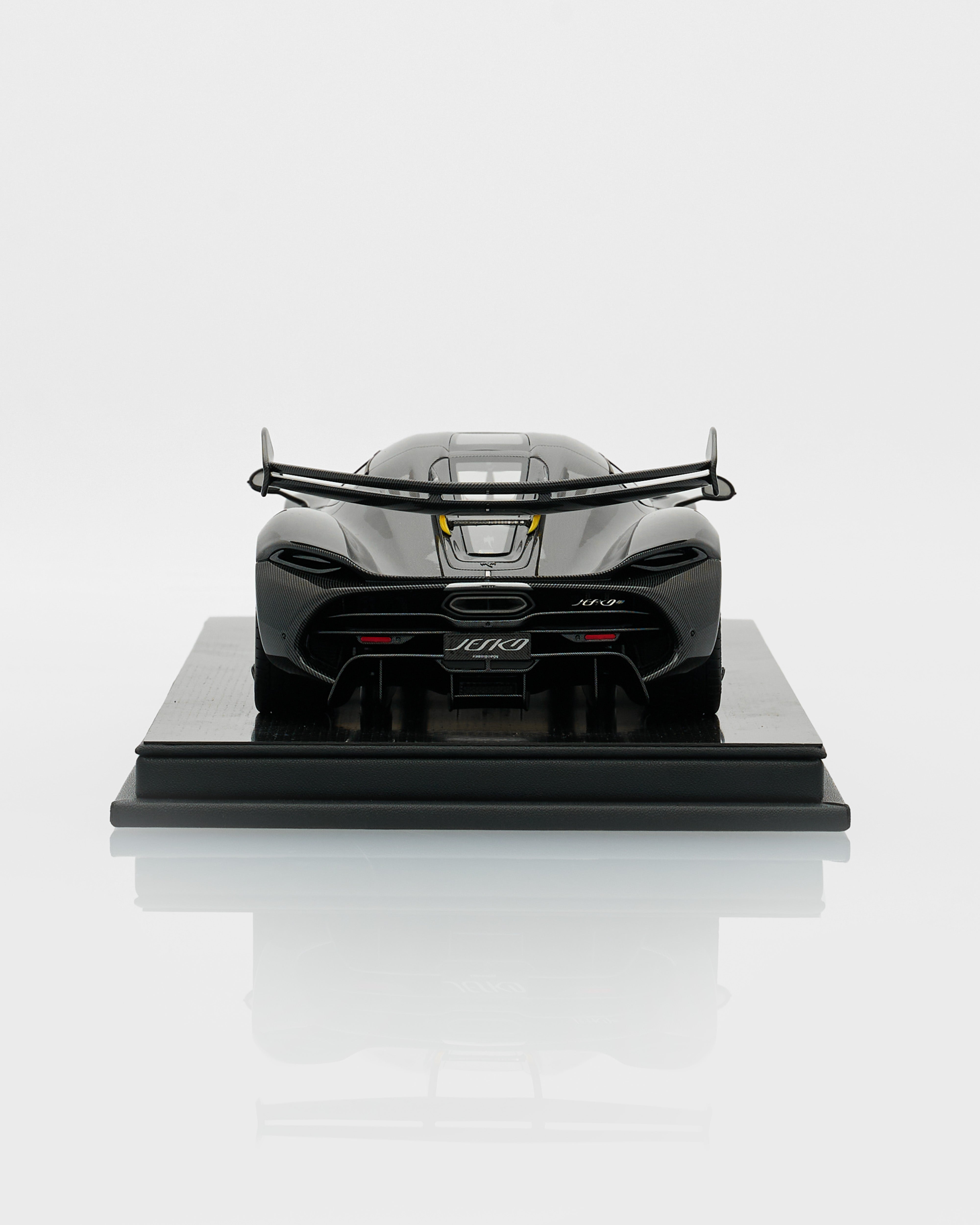 Model of a sports car on a reflective black platform with a white background
