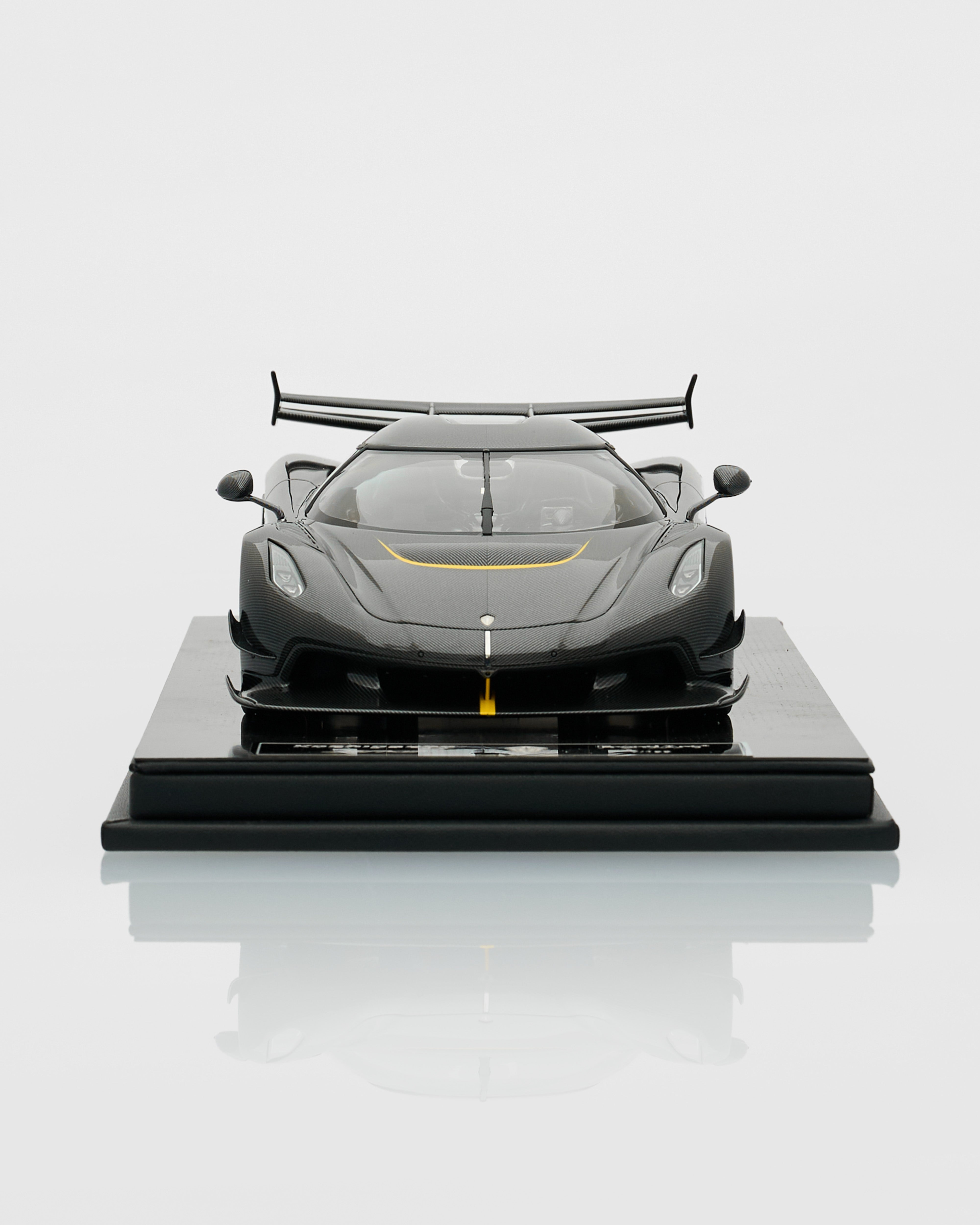 Model of a sports car on a reflective surface with a light gray background
