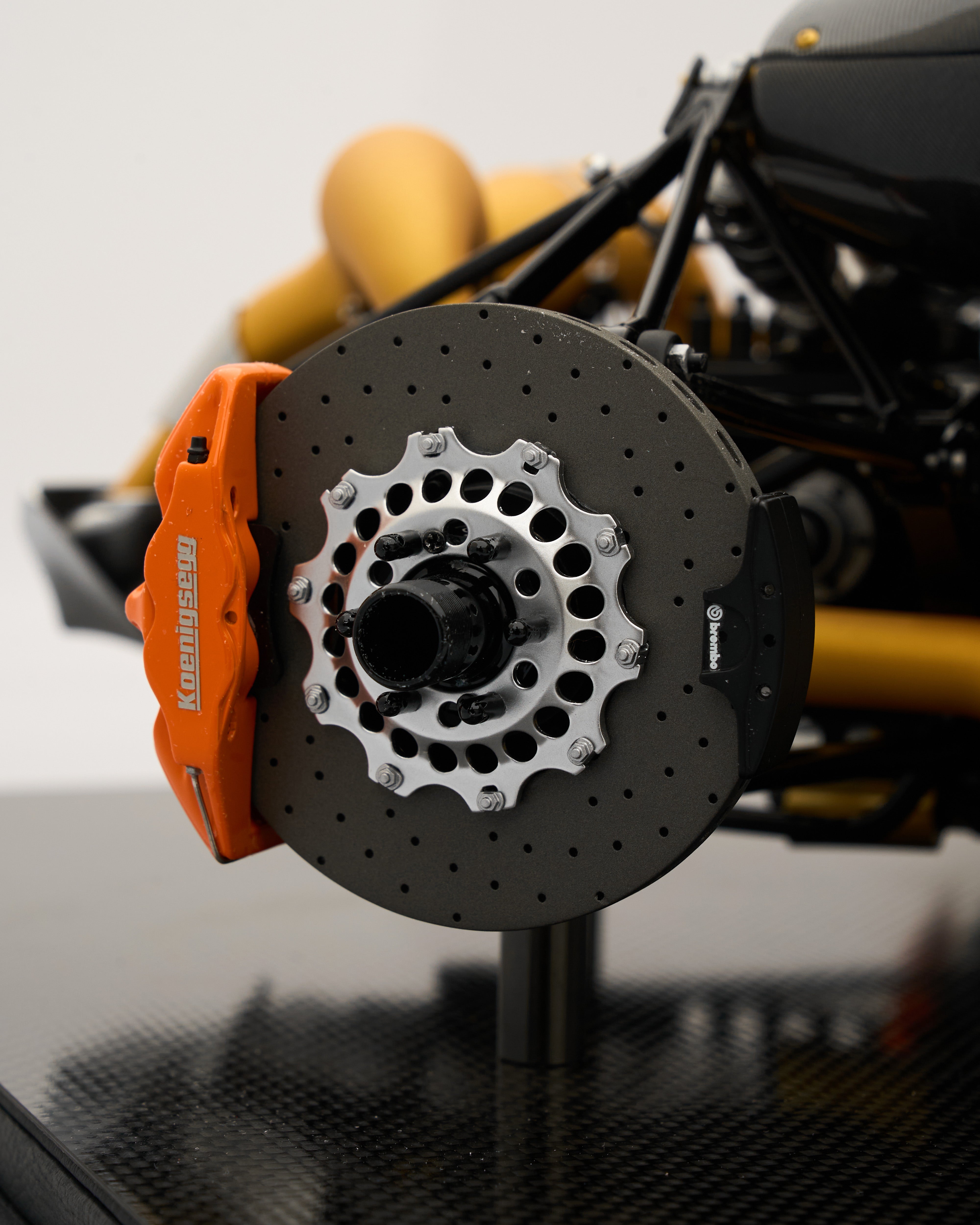 Close-up of a car brake disc with orange caliper on a blurred background