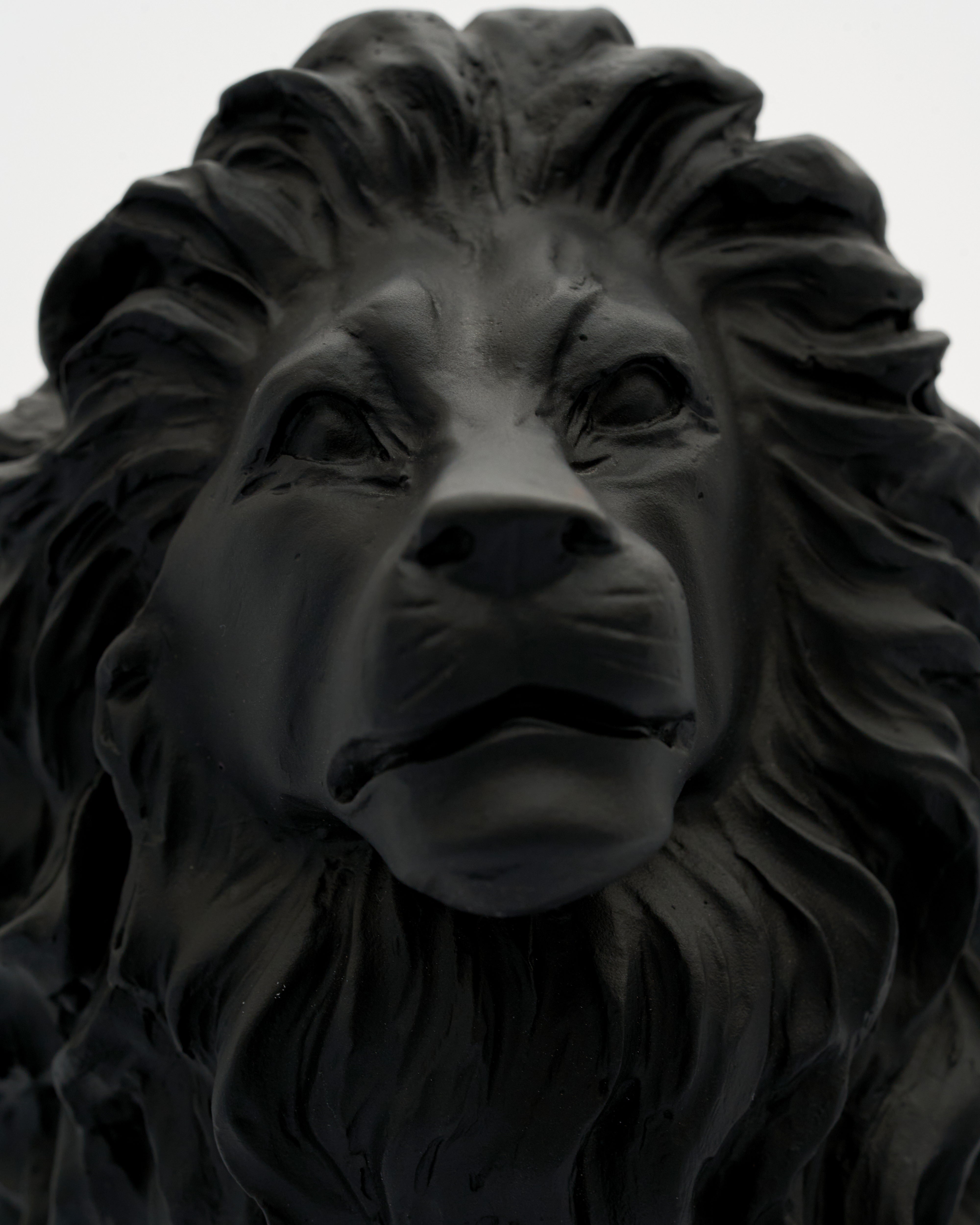 Black lion statue against a gray background