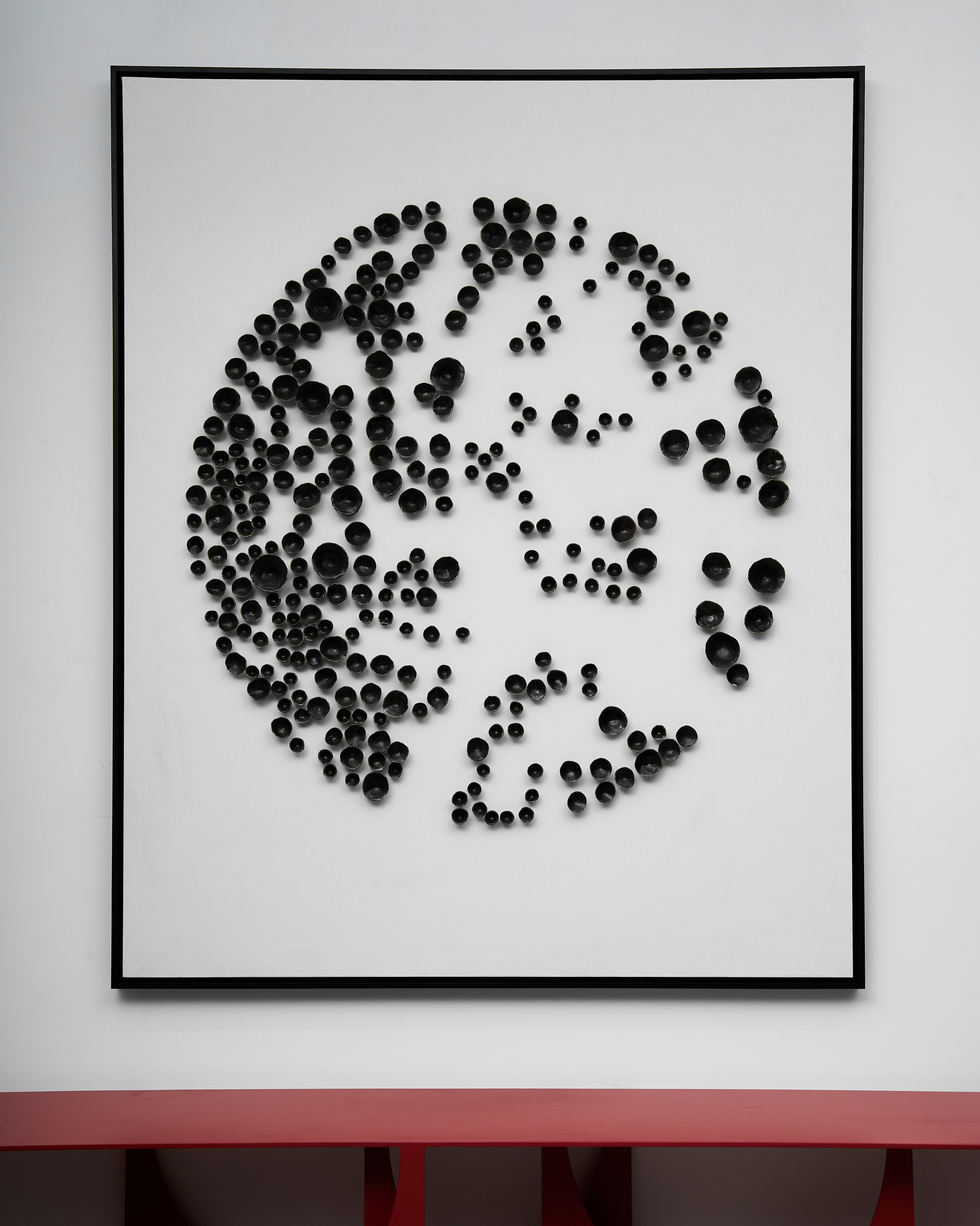 Framed artwork of a face made from black dots on a white background