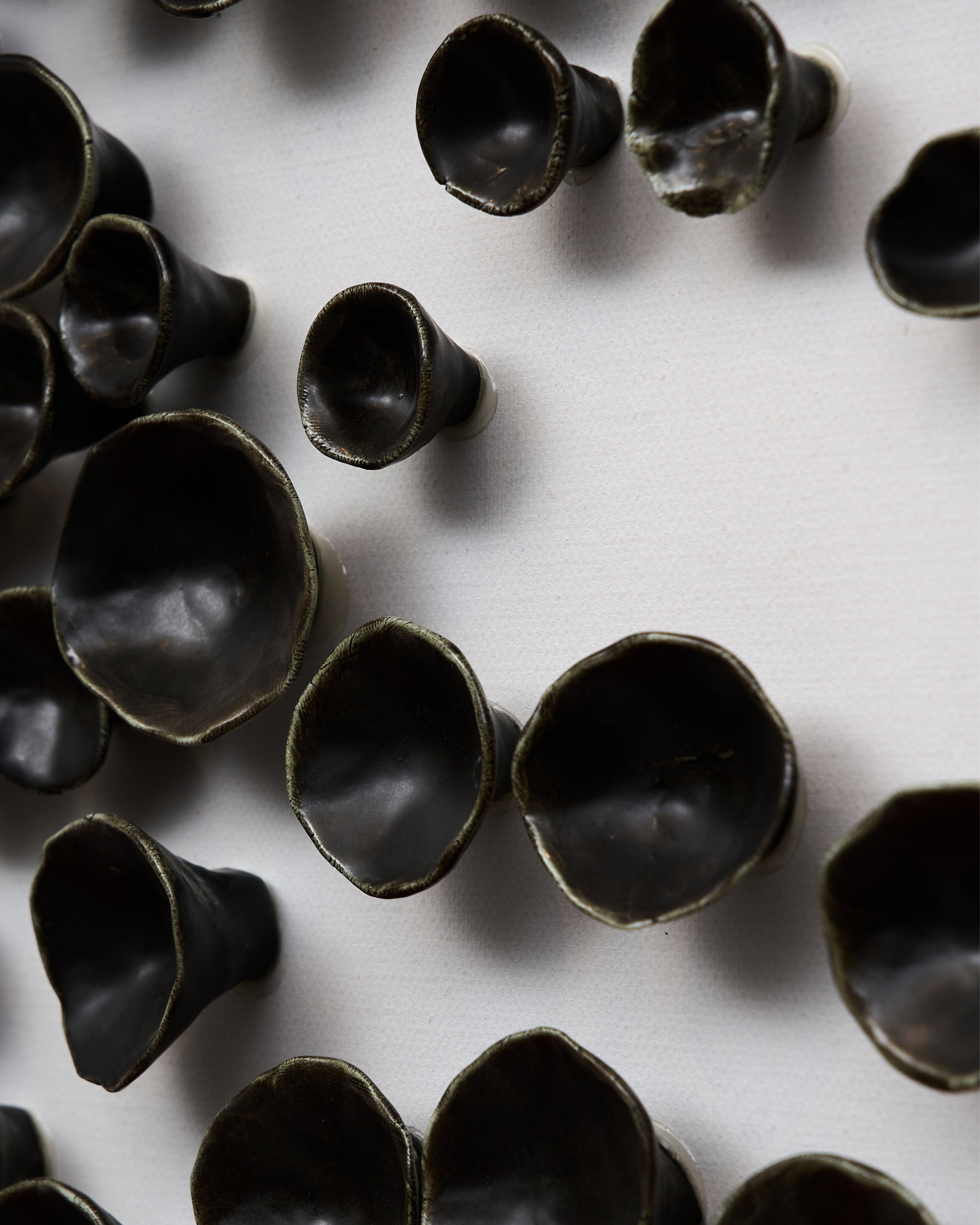 Dark brown ceramic cups on a white surface of wall art