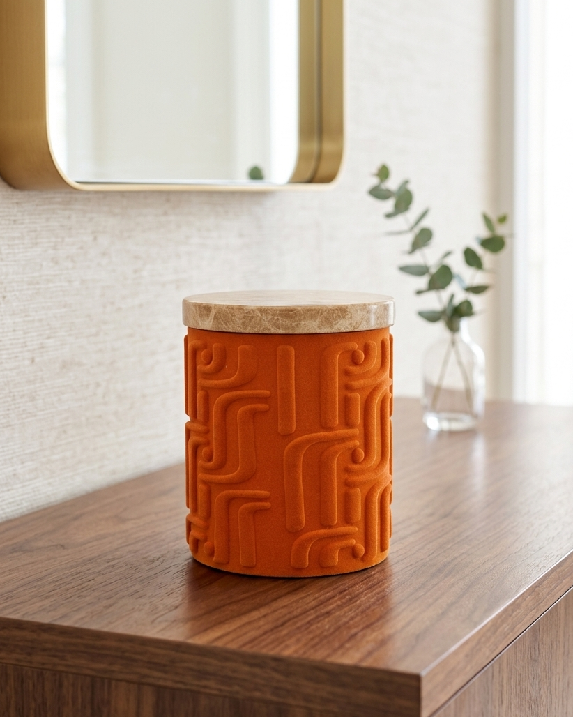 Orange textured jar decort with marble lid on a wooden surface