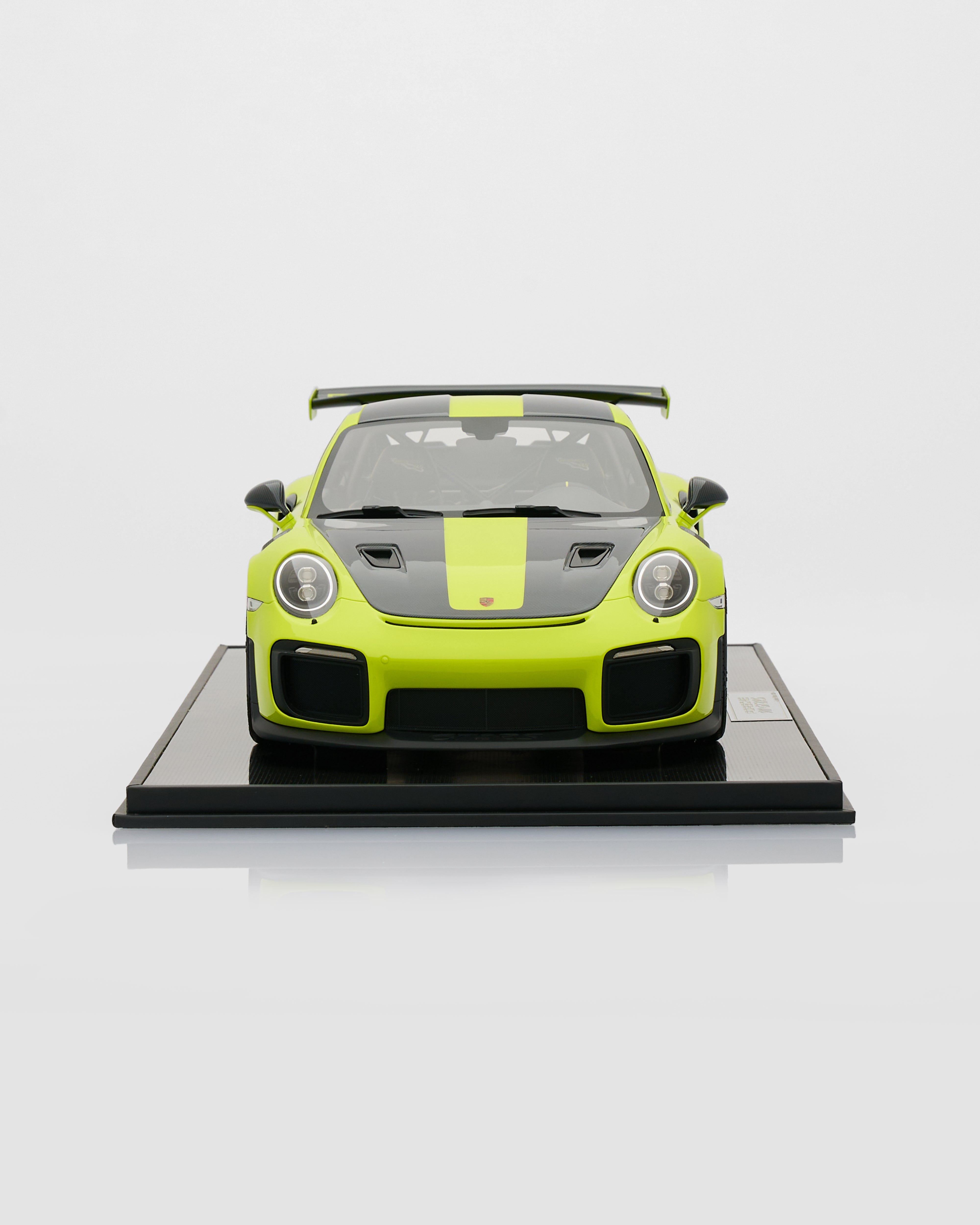 Model car on a black platform with a white background